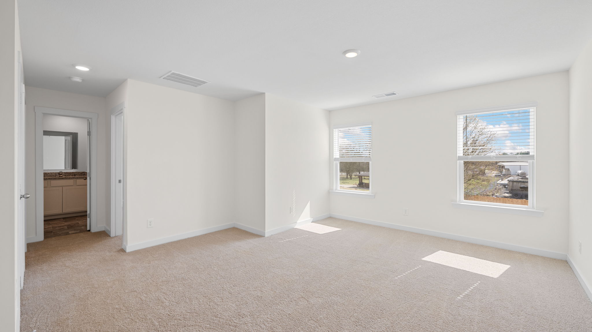 loft area with carpet and windows