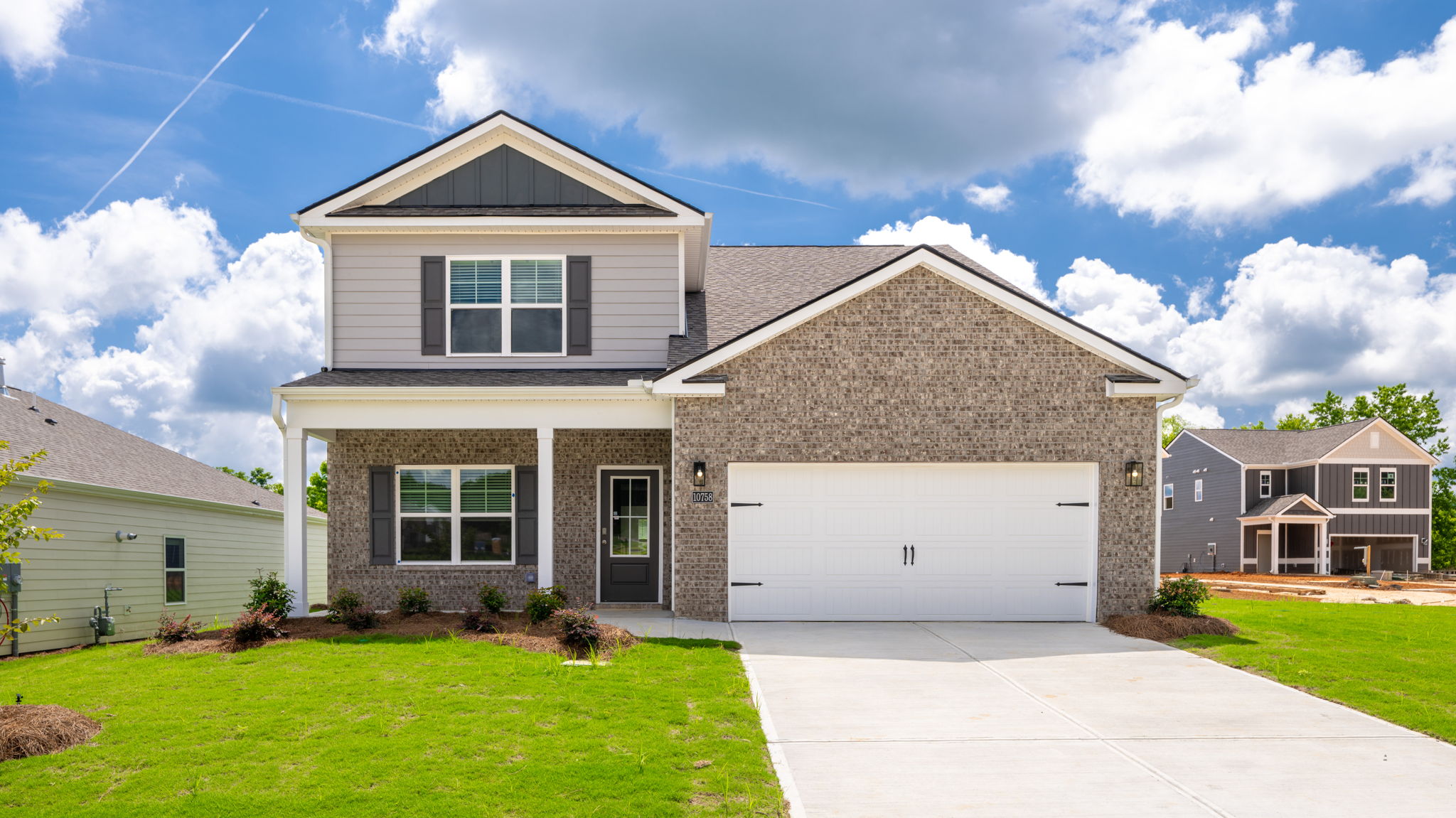two story home with two car garage under blue sky