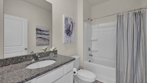 Guest bathroom with granite countertop between guest bedrooms