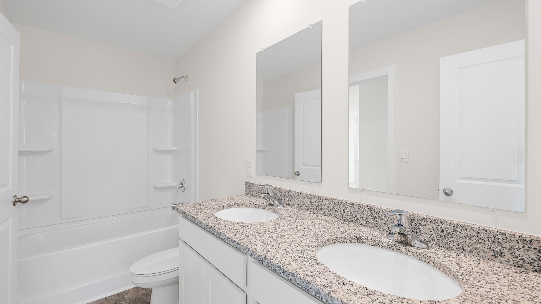 full bathroom with double vanity and shower/tub duo