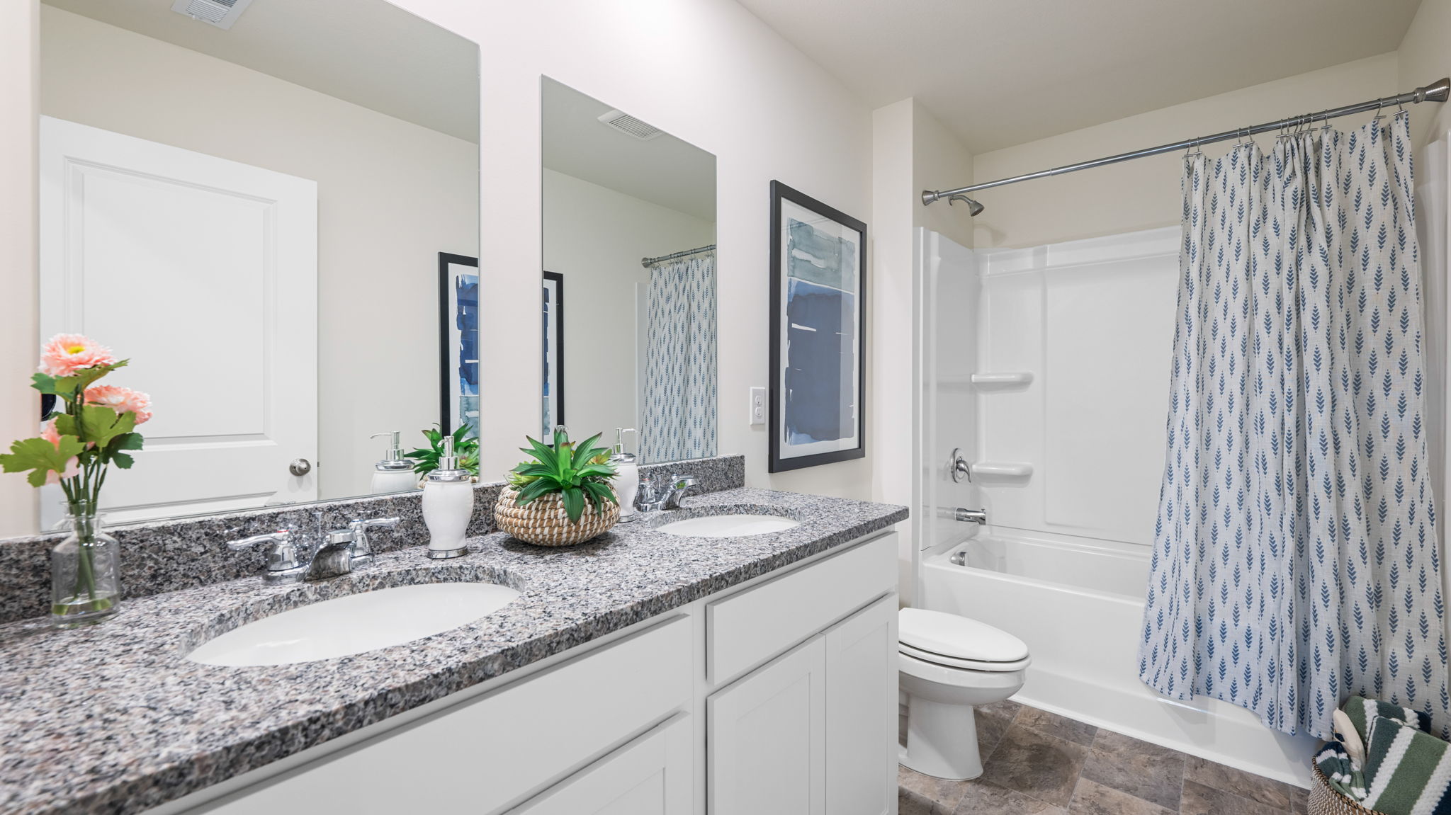 the bathroom has two sinks and white cabinets