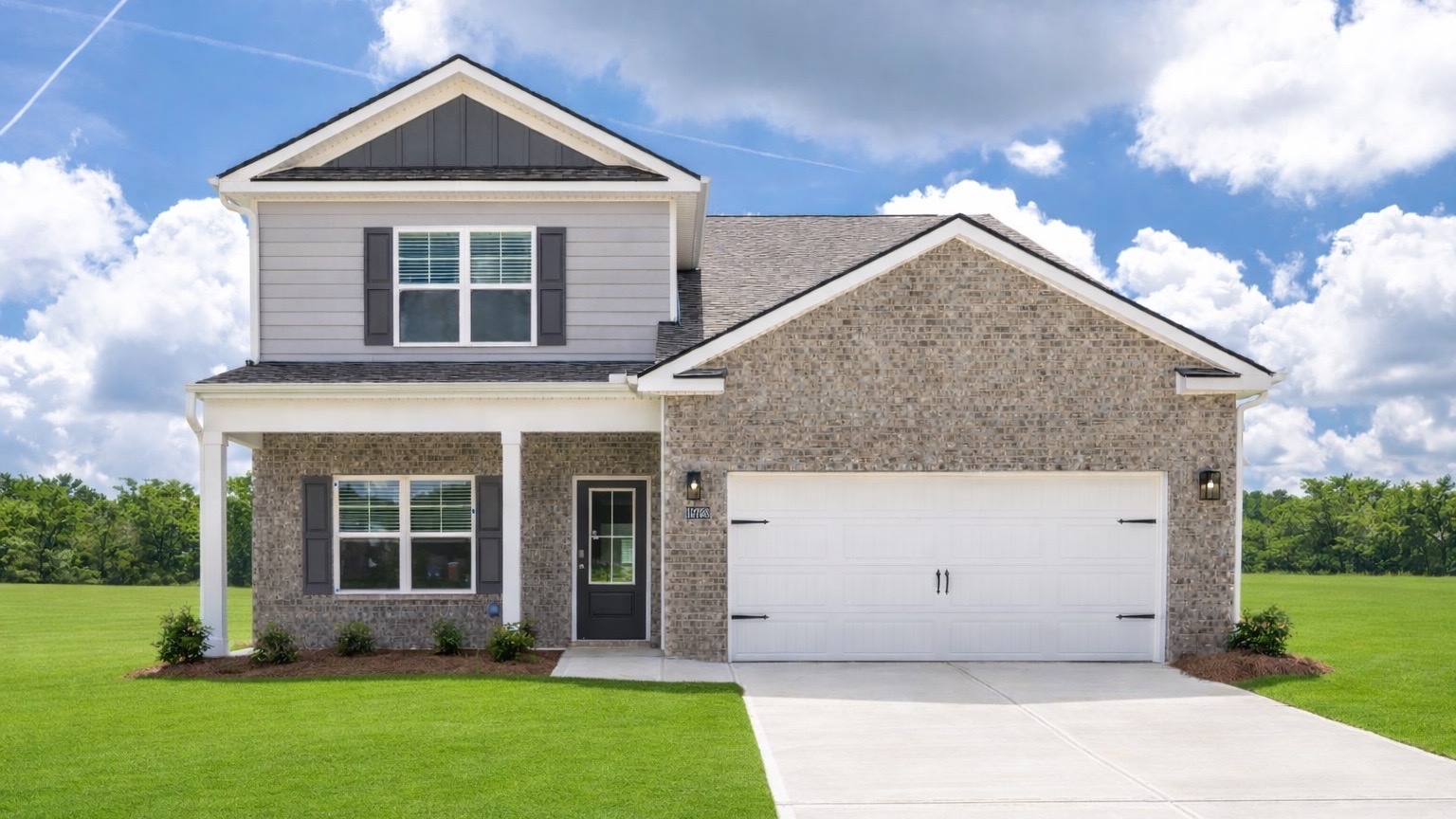 two story home with two car garage with green grass