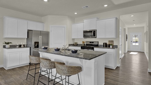 Kitchen with white cabinets and island with countertop seating