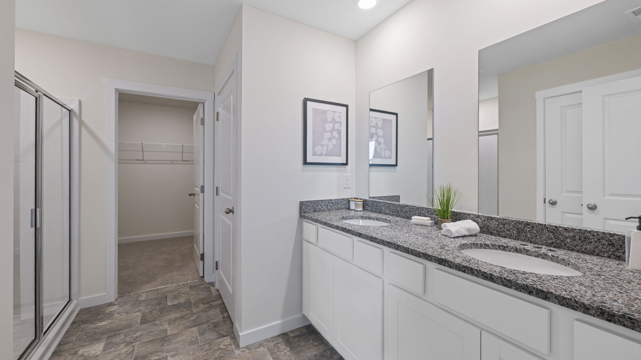 primary bathroom with double vanity and walk-in shower