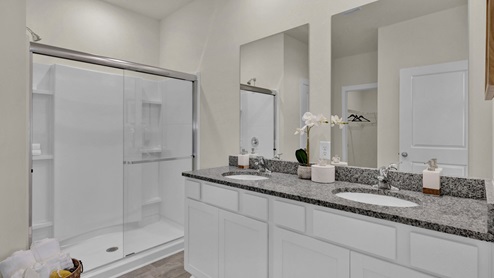 Primary bathroom with double vanity and glass shower