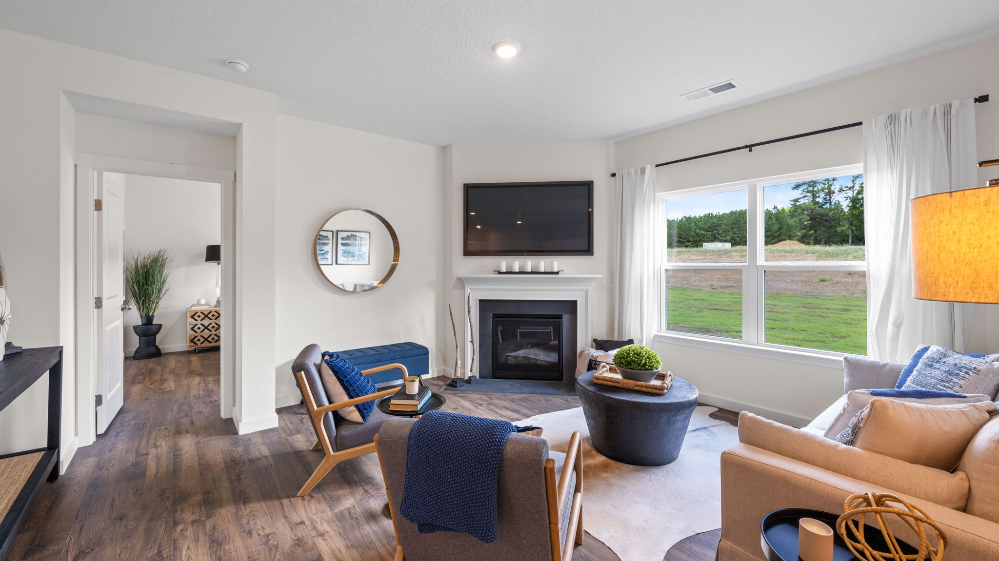 living area with television above mantel and exterior windows