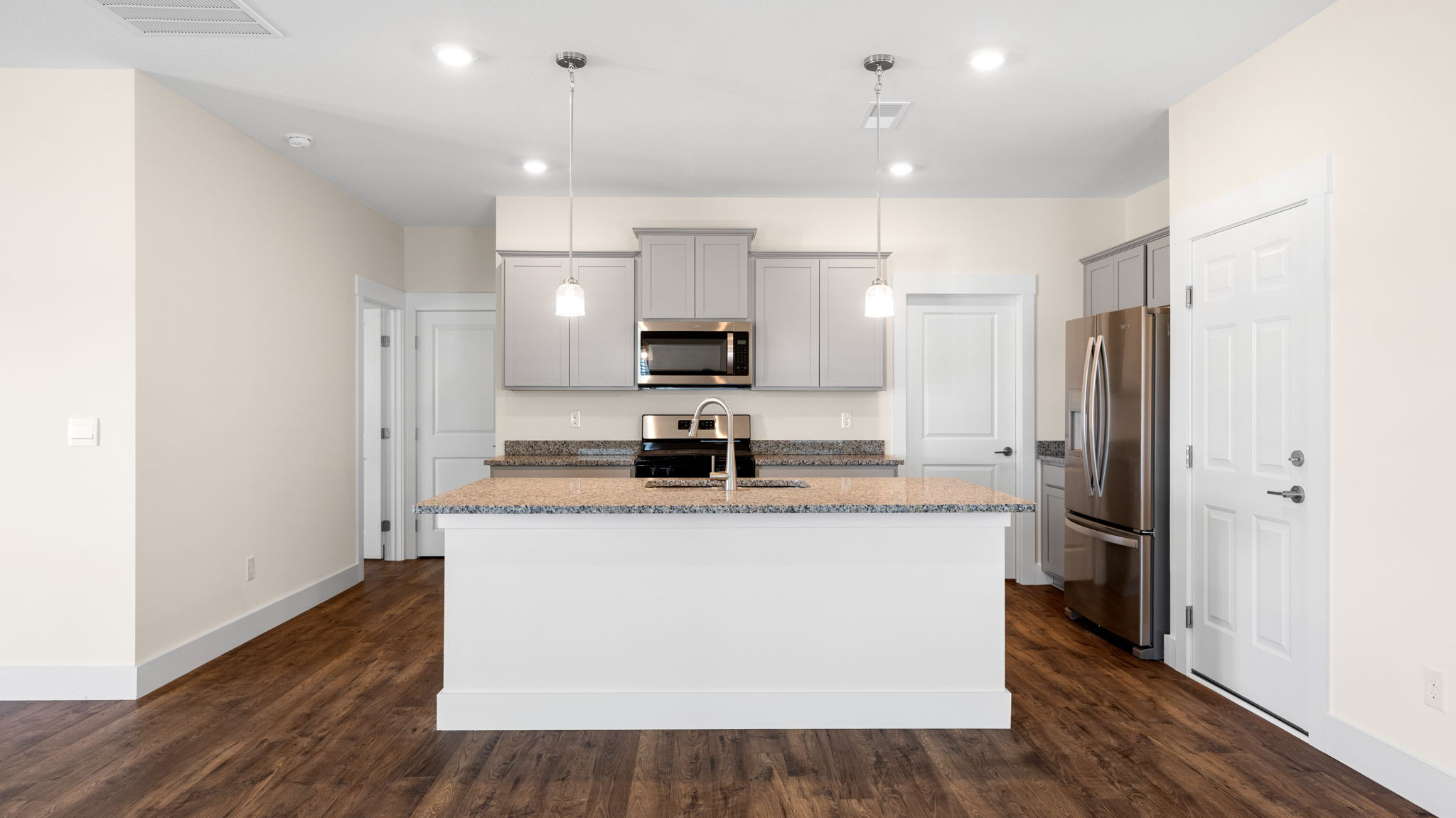 The kitchen comes equipped with a spacious pantry, an island, and countertop seating