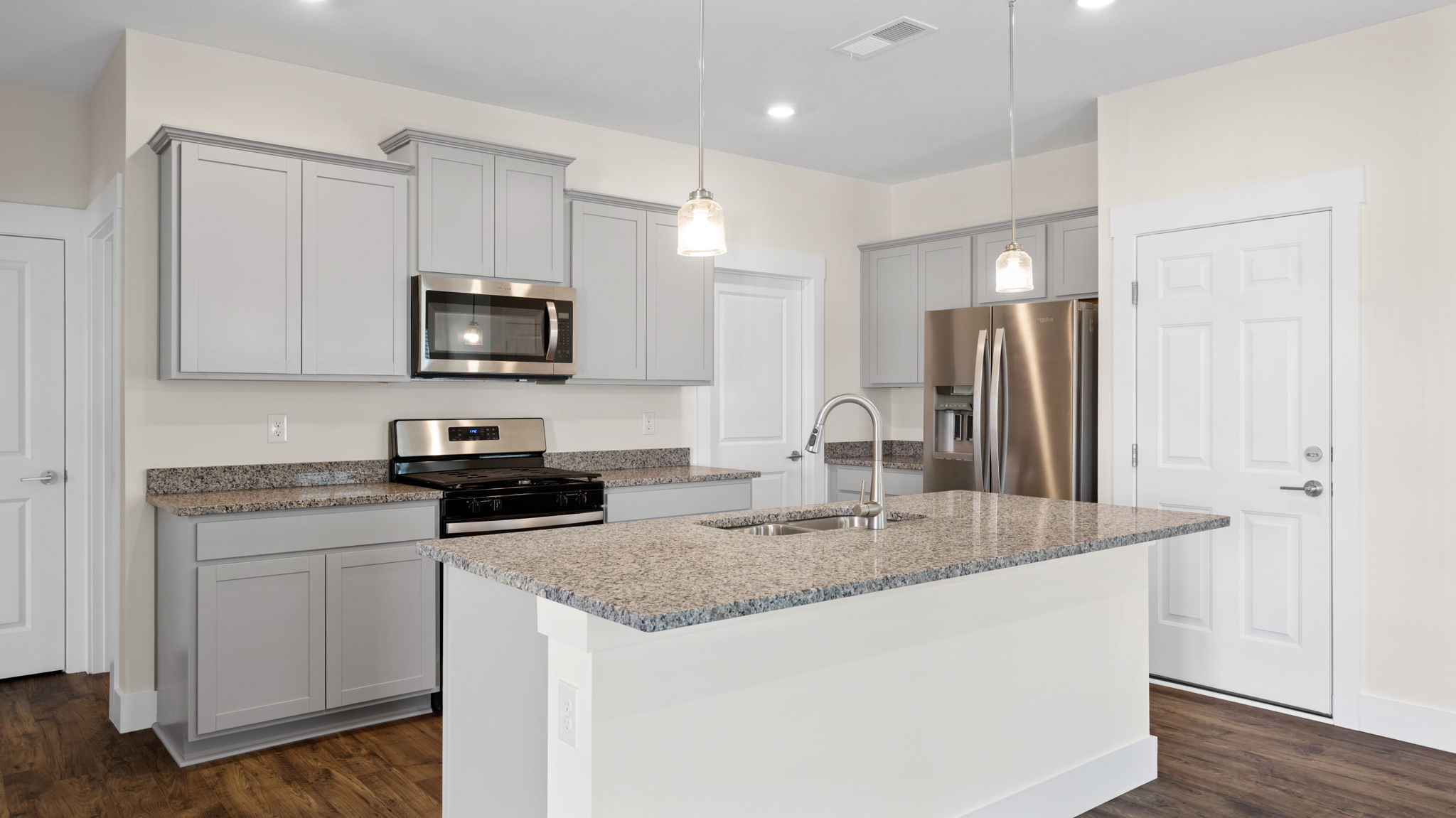 The kitchen comes equipped with a spacious pantry, an island, and countertop seating