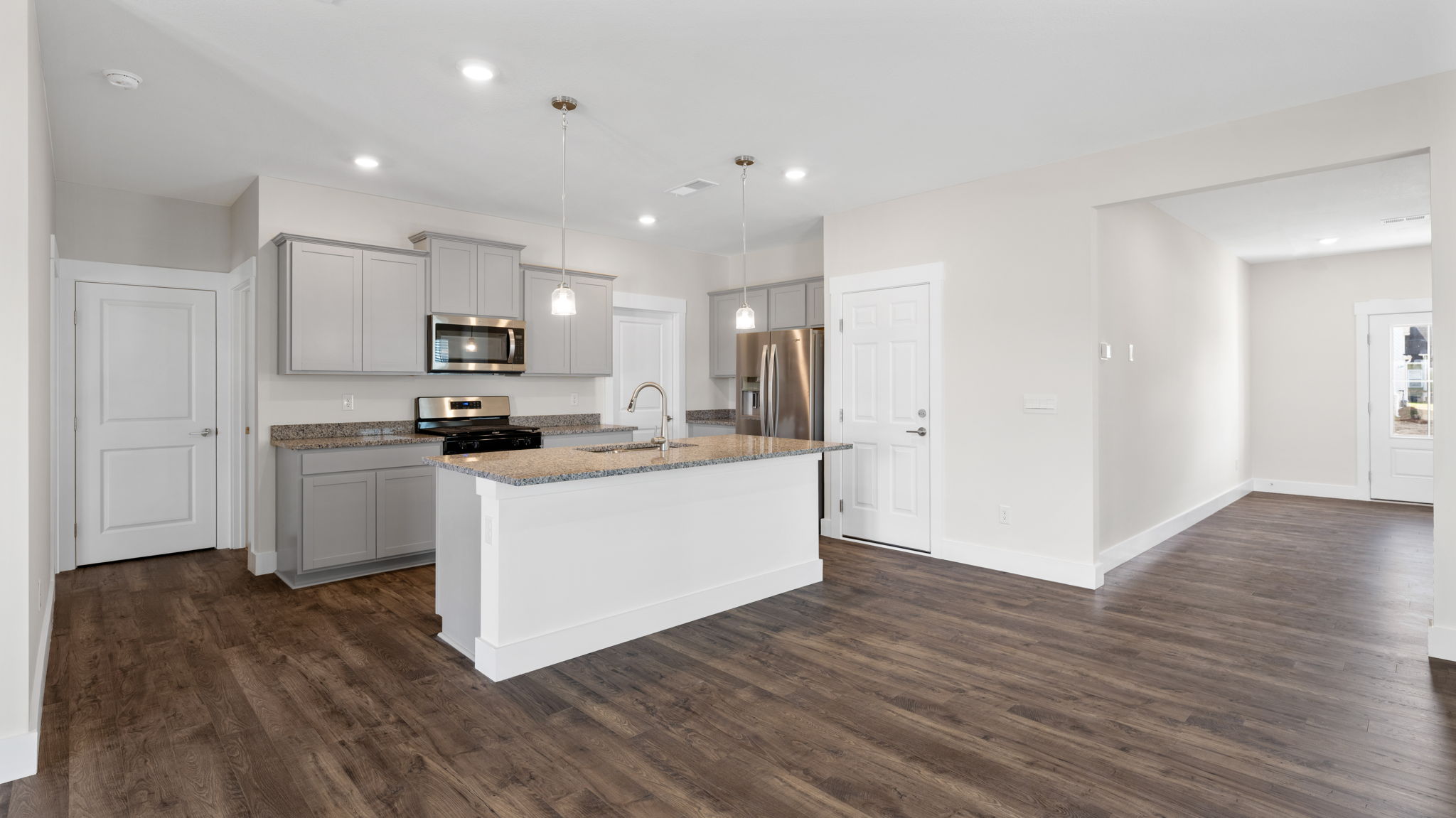 The kitchen comes equipped with a spacious pantry, an island, and countertop seating and cabinets.