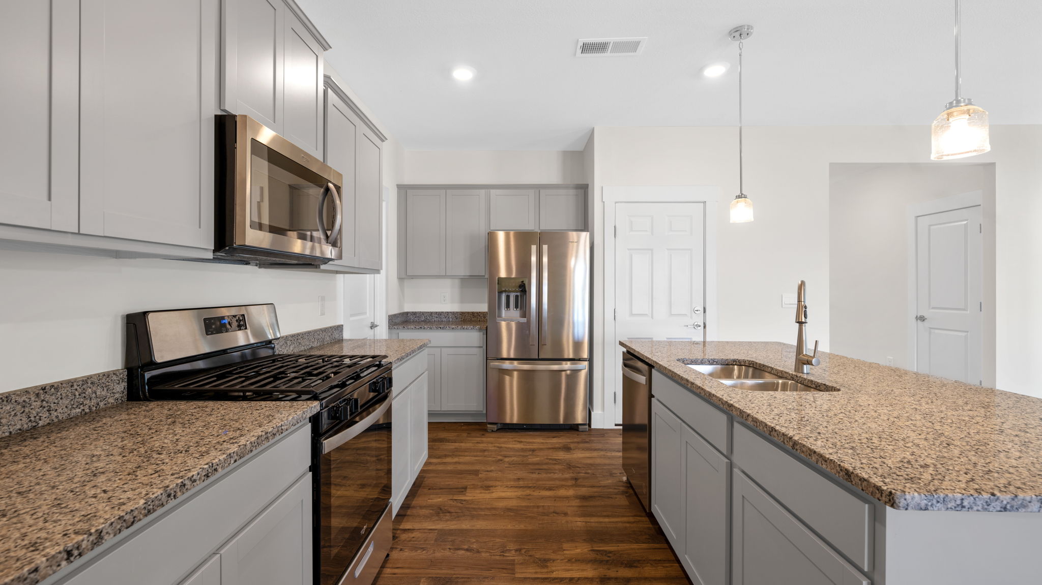 The kitchen has an island with countertop seating and appliances.