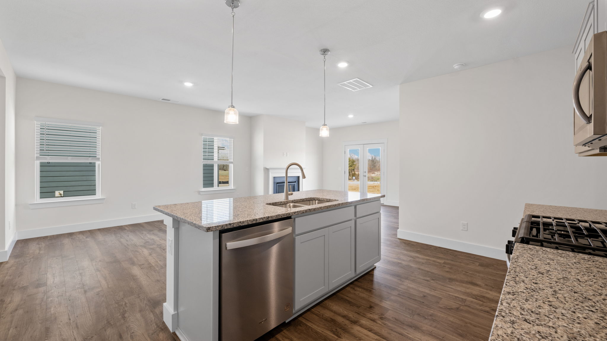 The kitchen comes equipped with a spacious pantry, an island, and countertop seating and opens into the dining area.