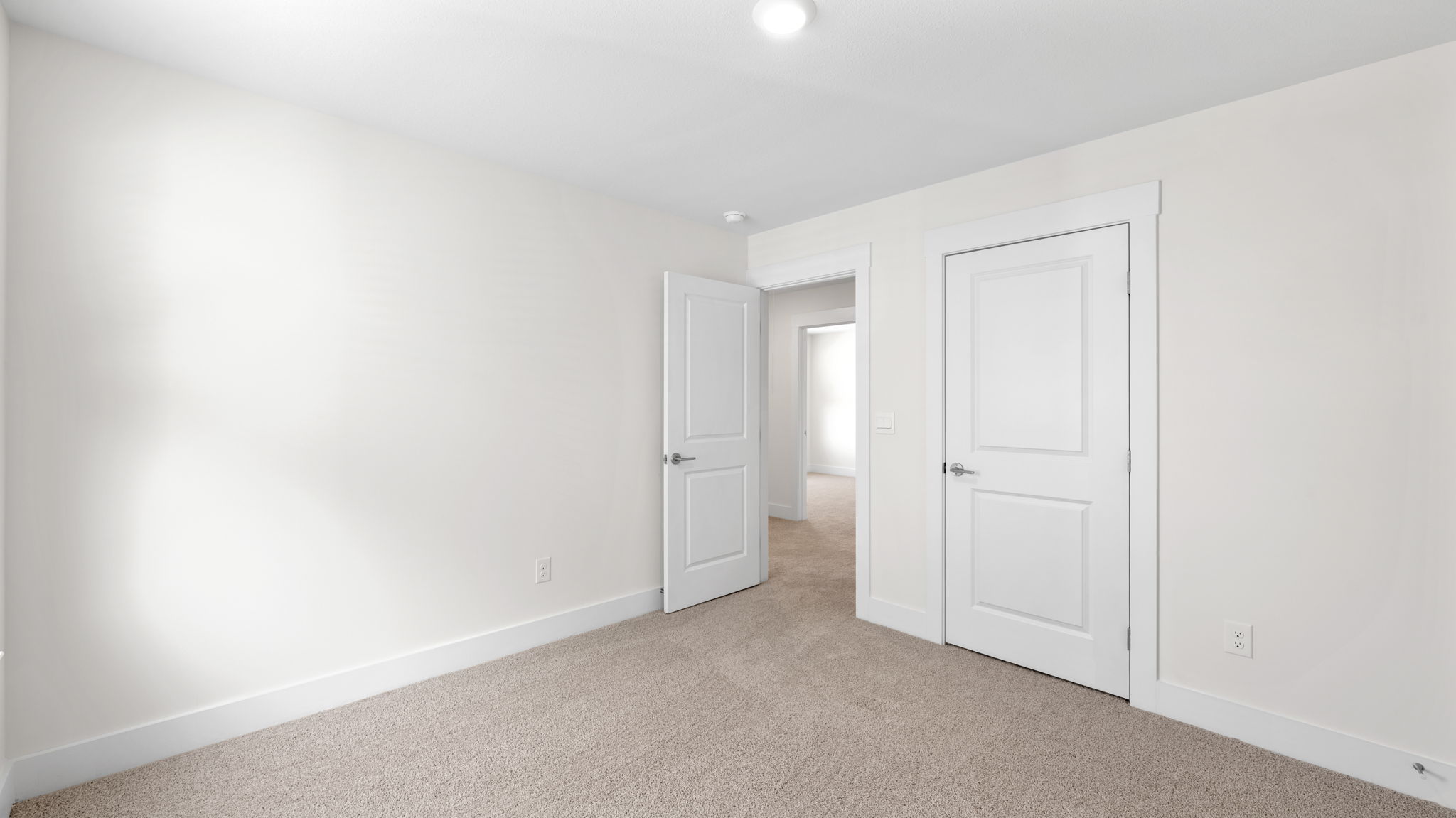 The bedroom has a large window and recessed lighting.