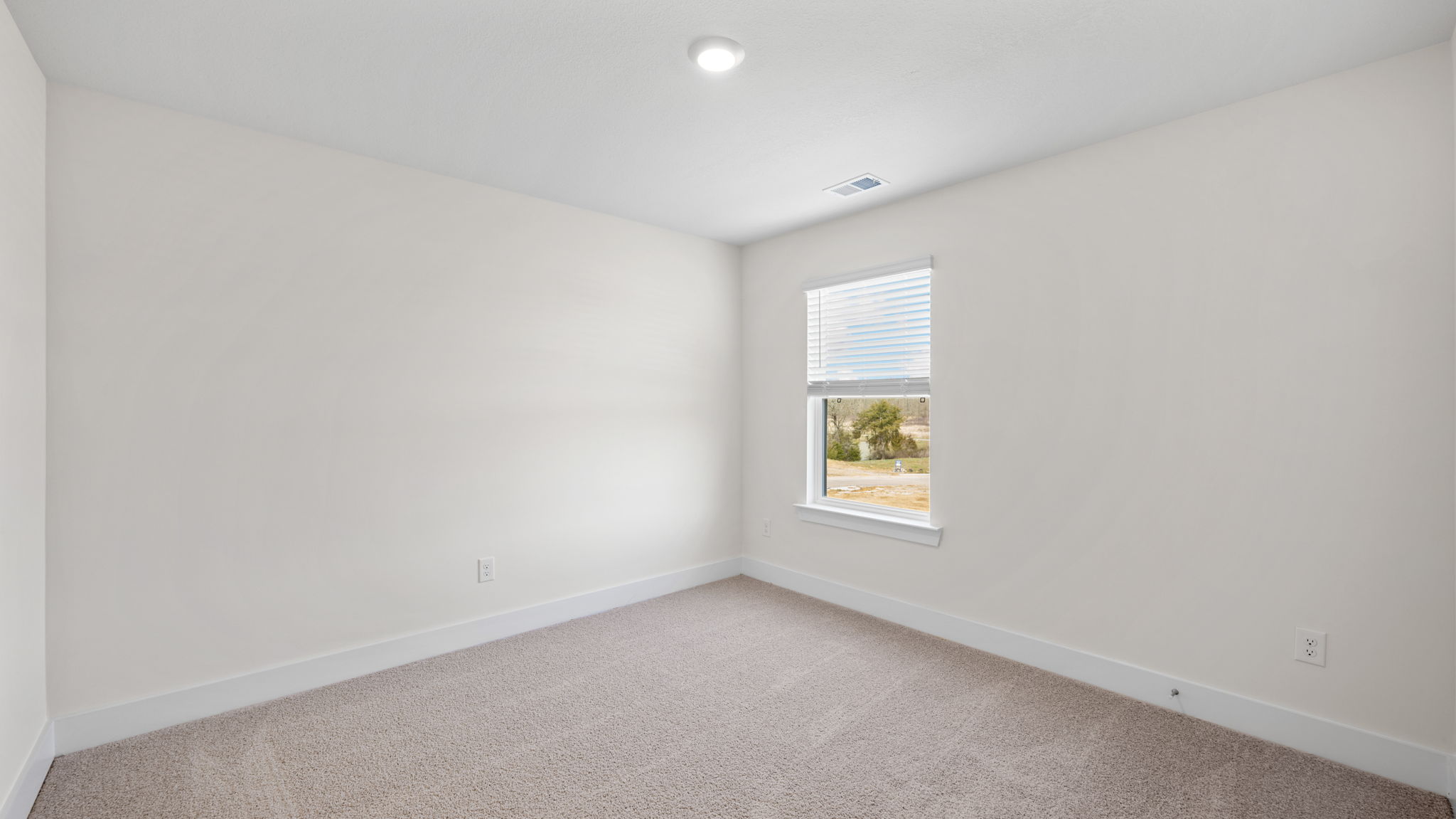 The bedroom has a large window and recessed lighting.
