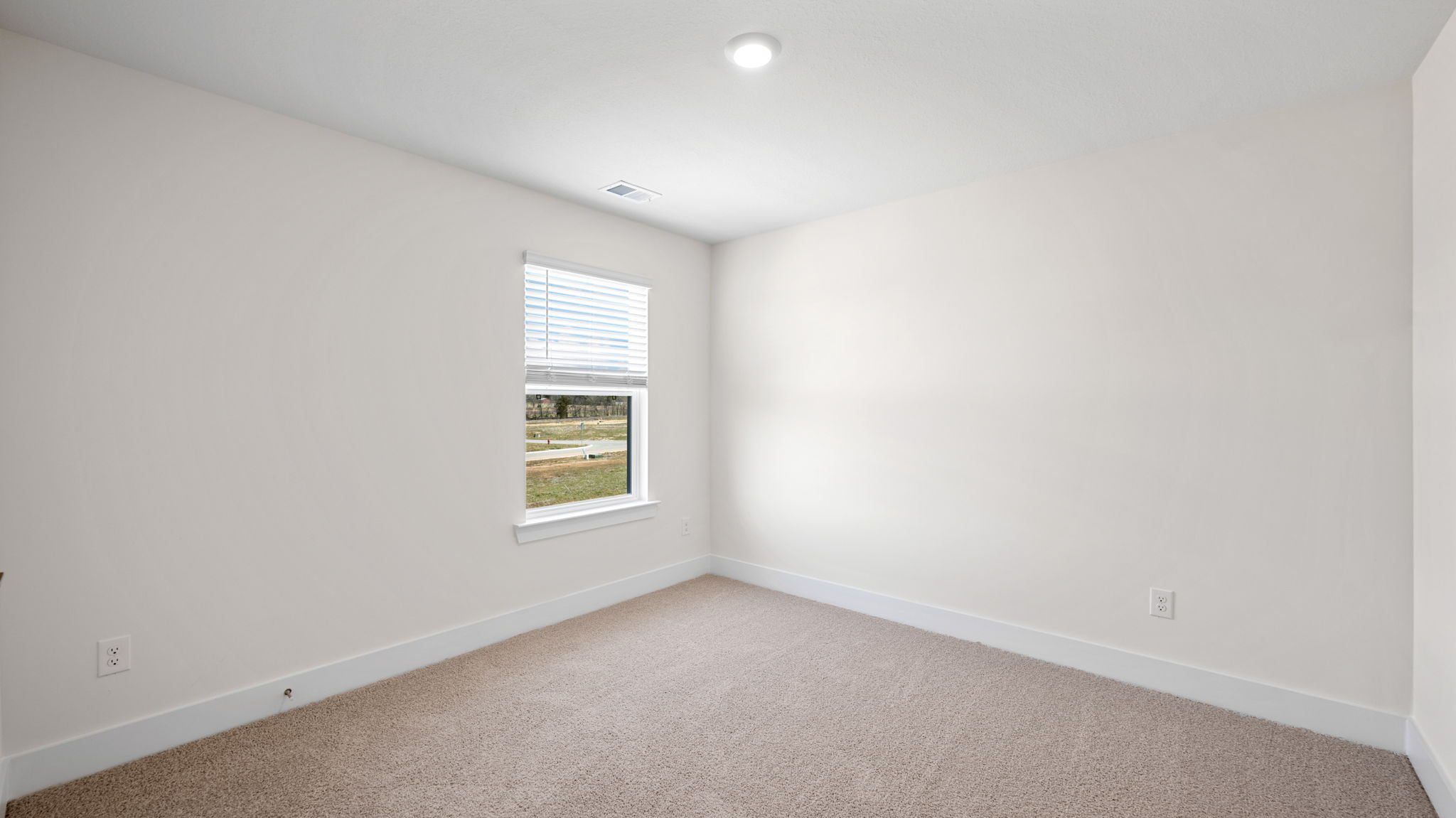 The bedroom has a large window and recessed lighting.