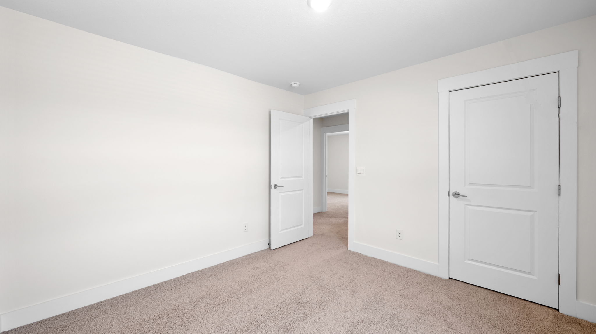 The bedroom has a large window and recessed lighting.