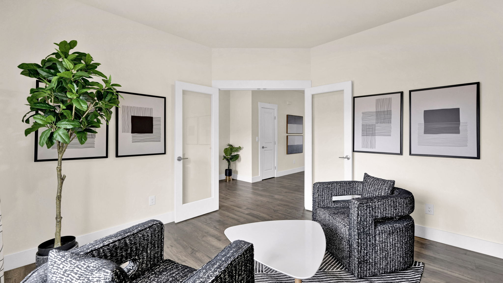 two chairs and small table with art on walls