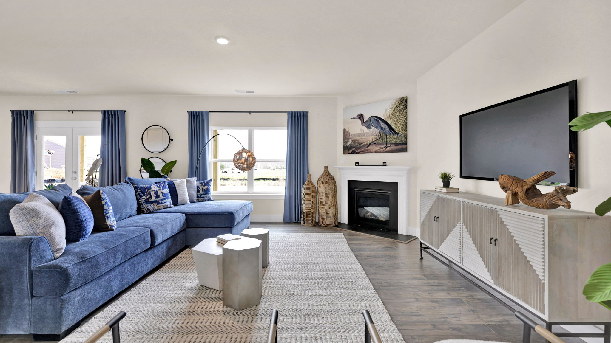 living area with blue couch and television on wall
