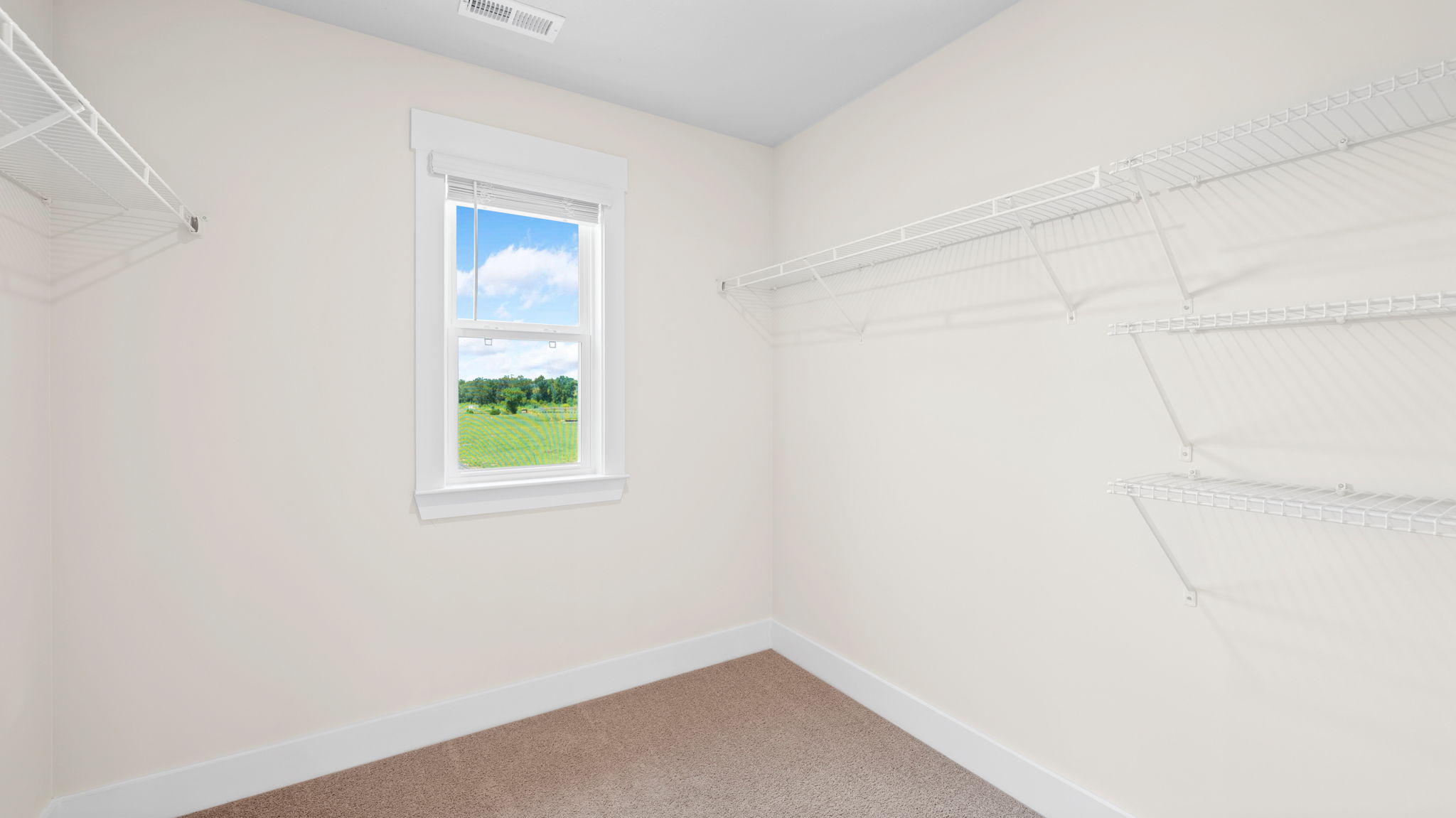 primary closet with shelving and window