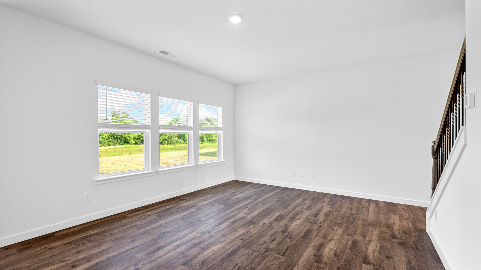 the living room has solid flooring and leads to the stairwell