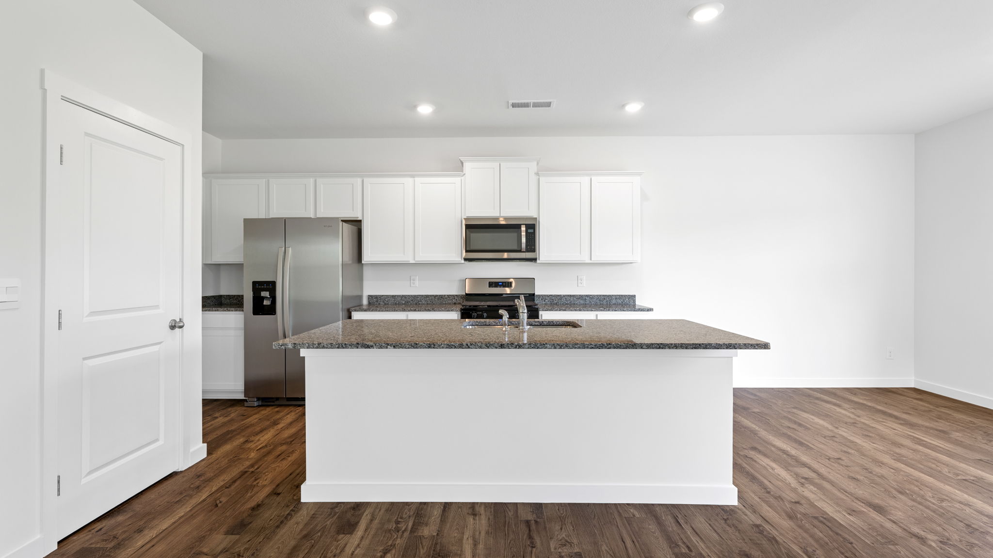 the kitchen has an island and stainless steel appliances