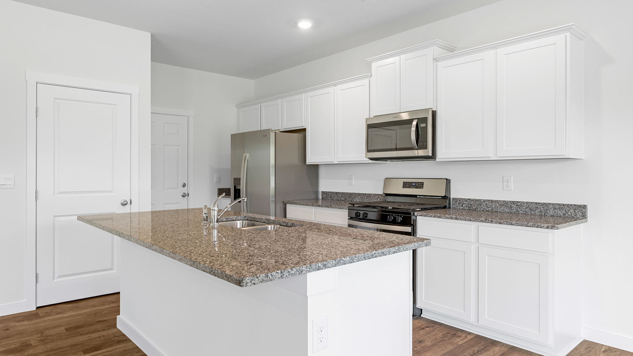 the kitchen island has a solid surface and cabinets