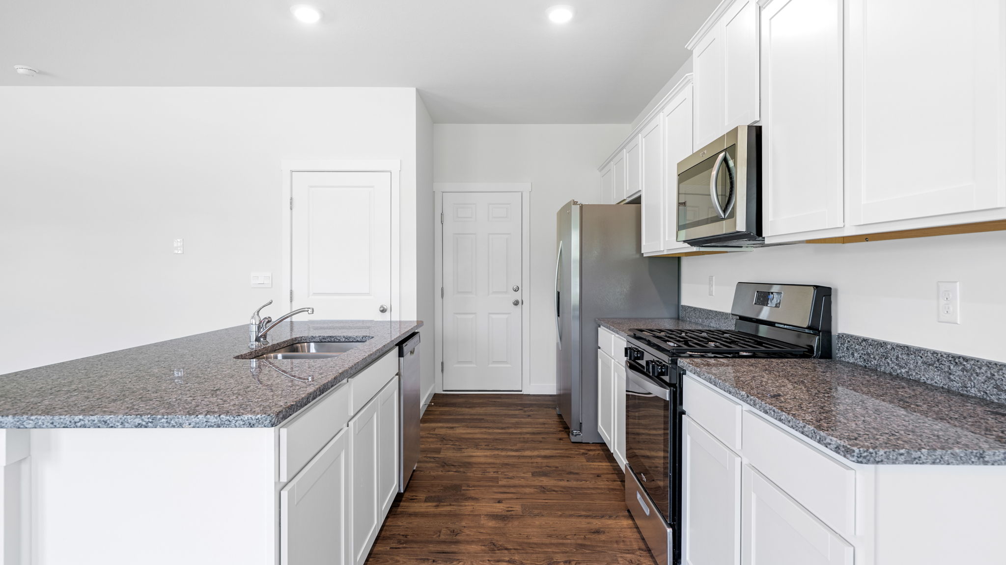 the kitchen has solid surfaces and cabinets
