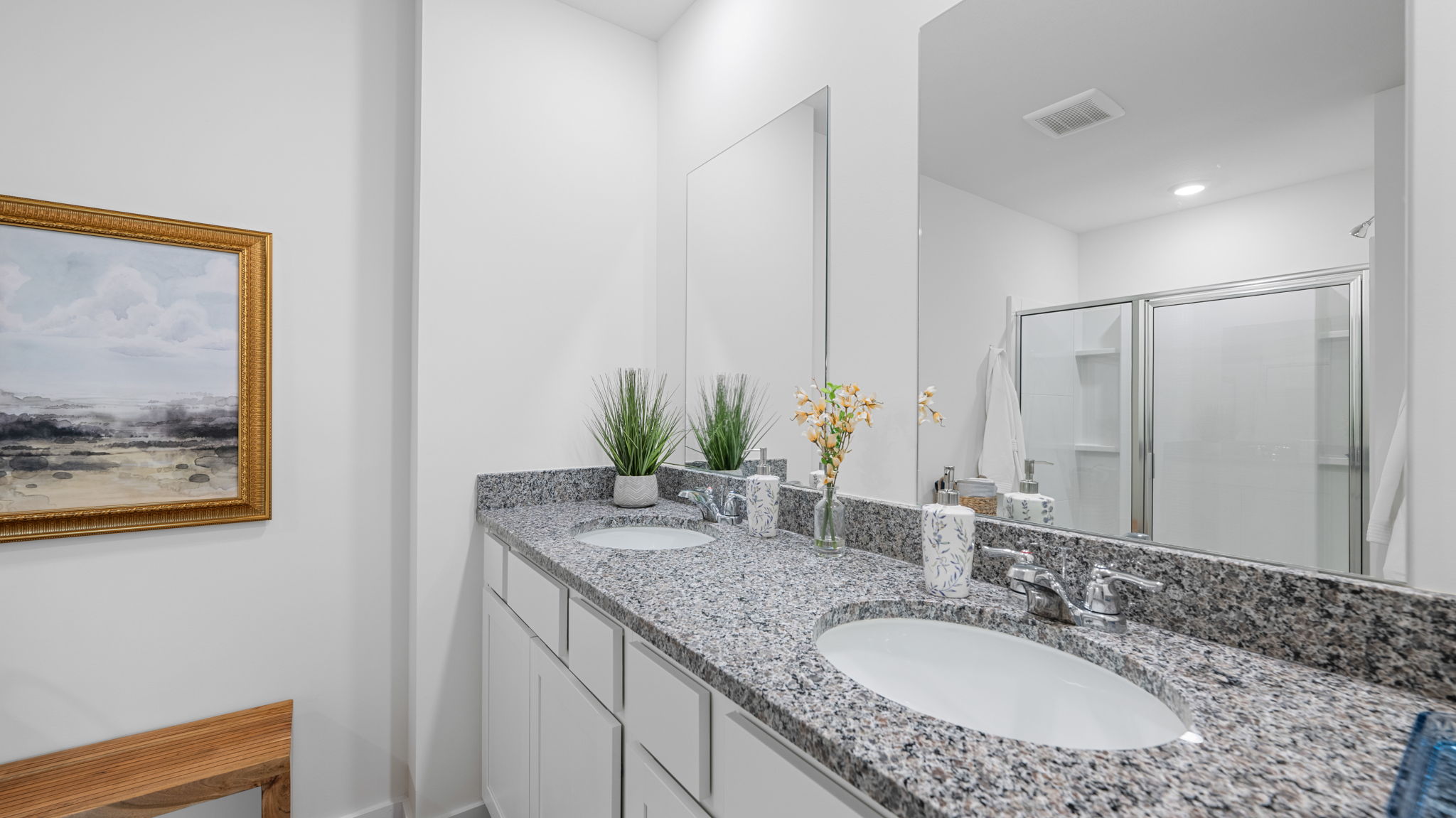 primary bathroom with double vanity and walk-in shower