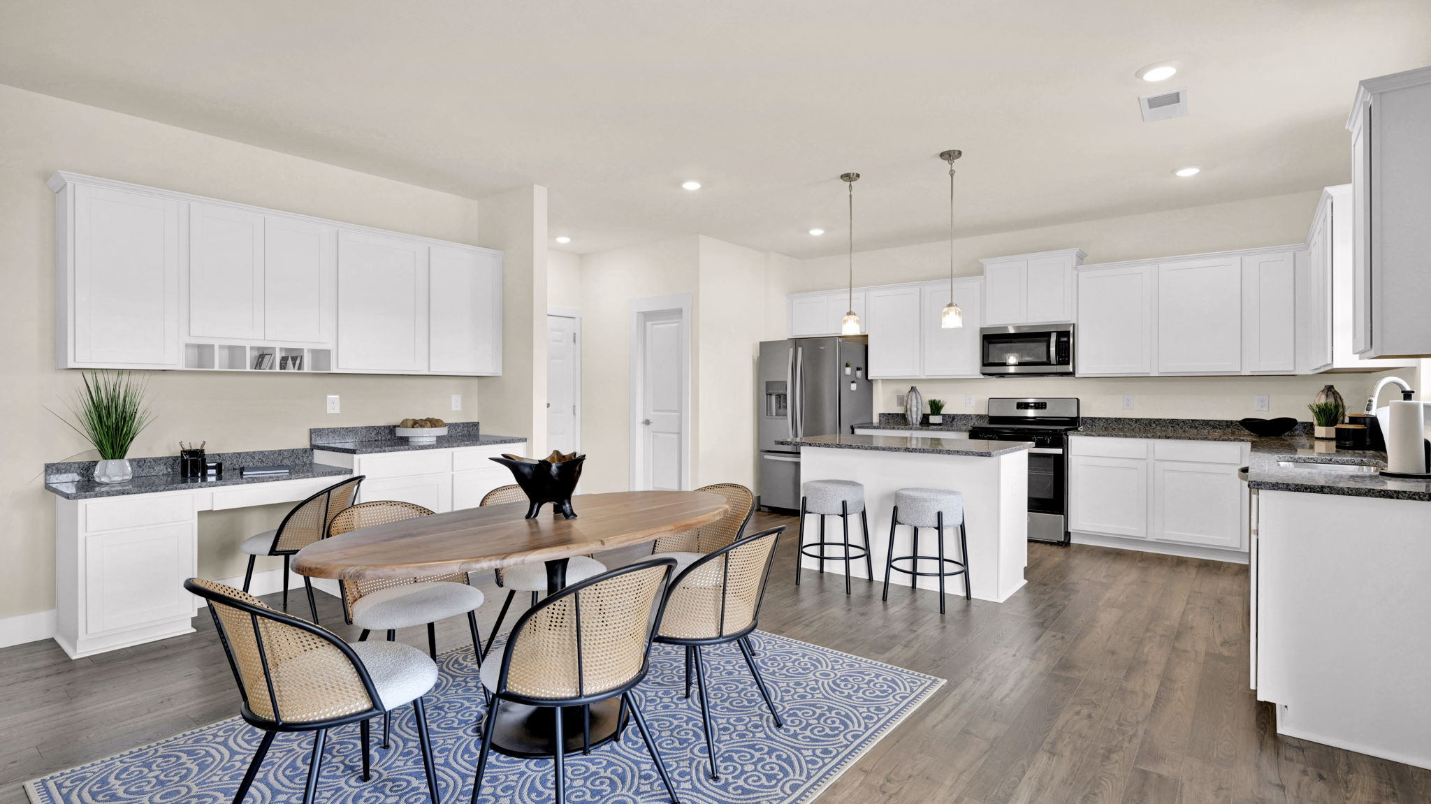 kitchen opens to dining area with blue rug