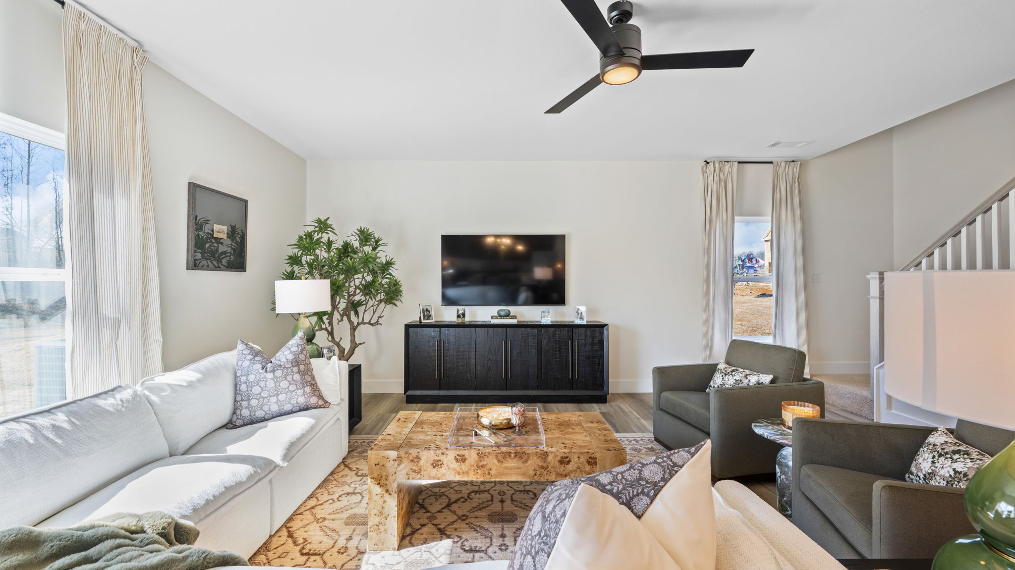 Living room with ceiling fan and double window