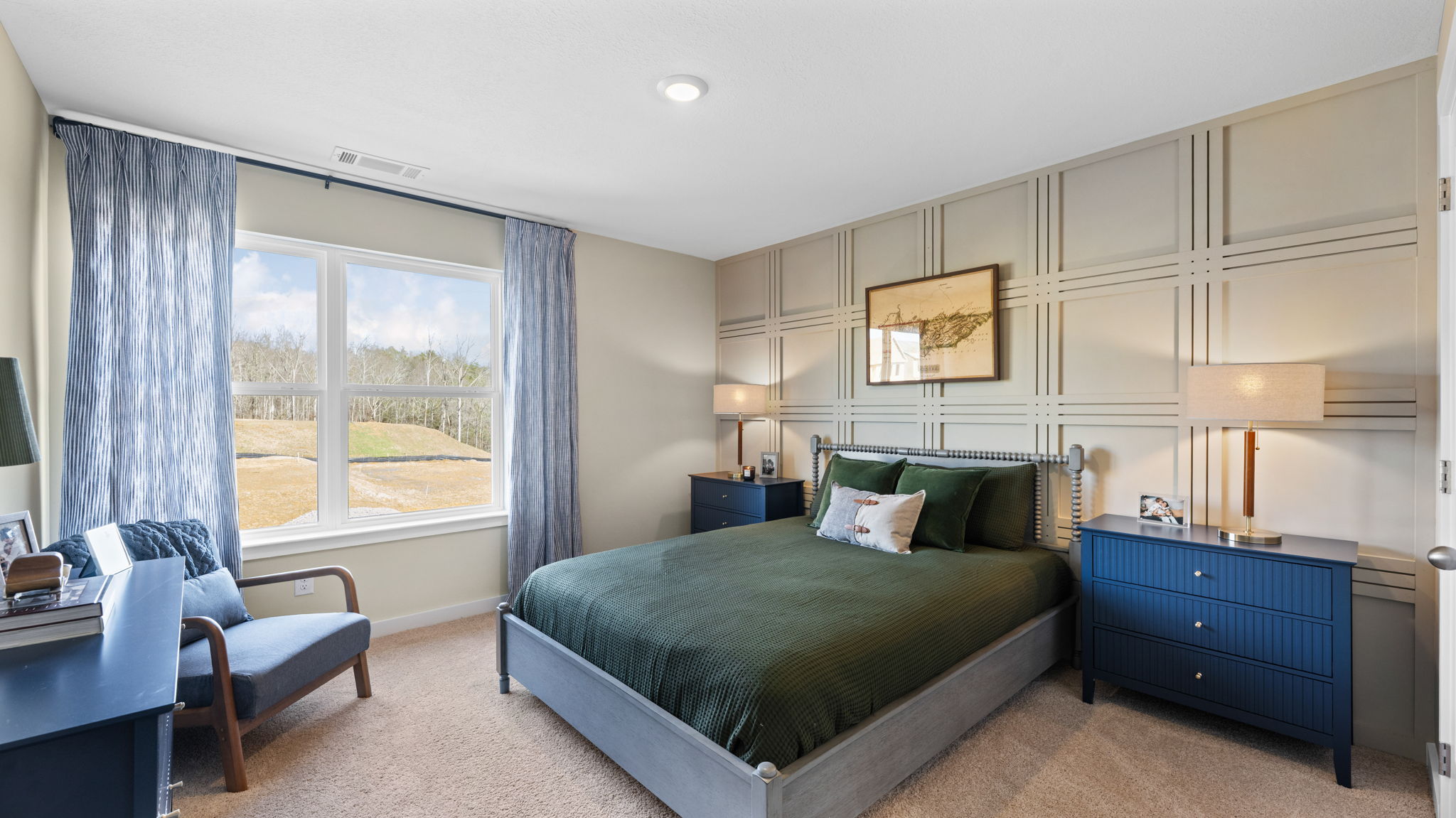 Guest bedroom on second floor with large double window and carpet