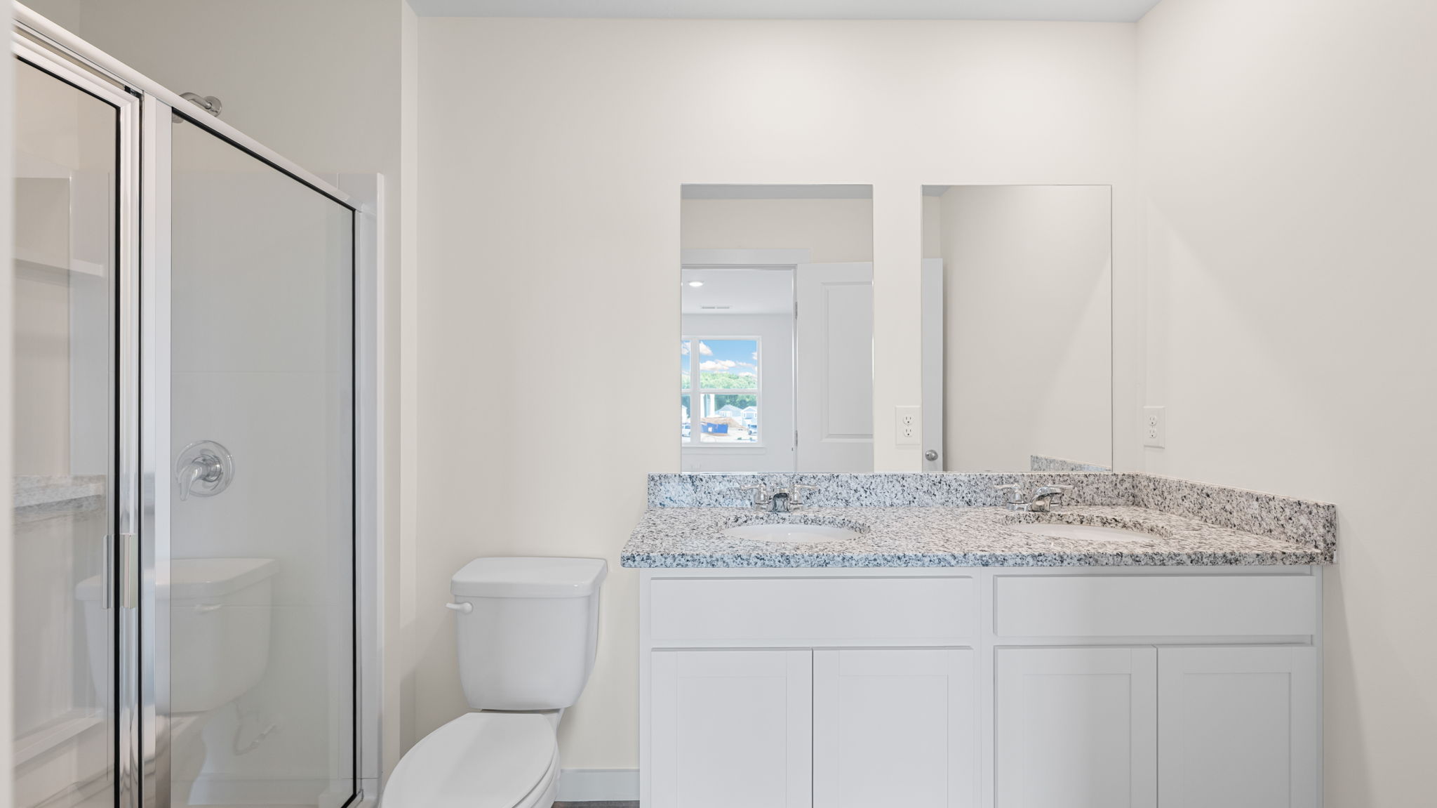 Primary bathroom with glass shower door and double bowl vanity
