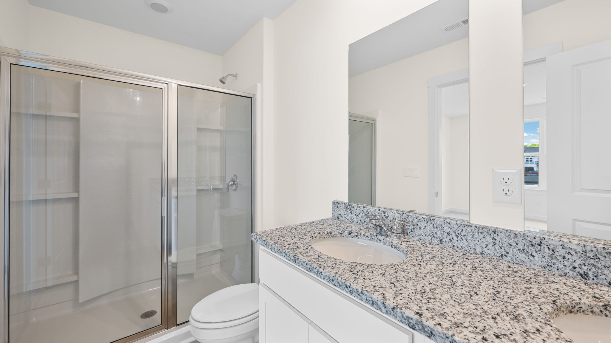 Primary bathroom with glass shower door and double bowl vanity