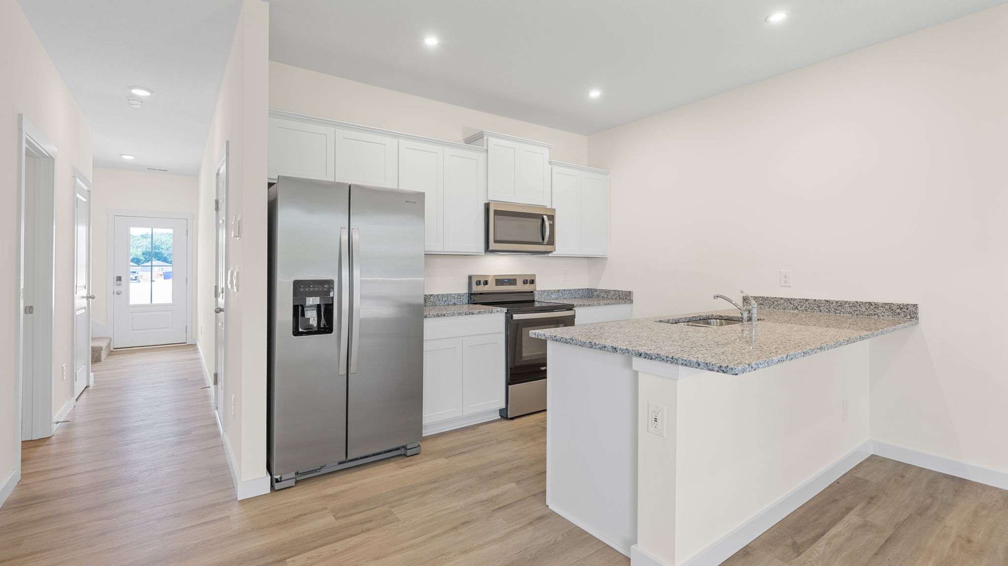 open concept kitchen with stainless steel appliances and hardwood floors