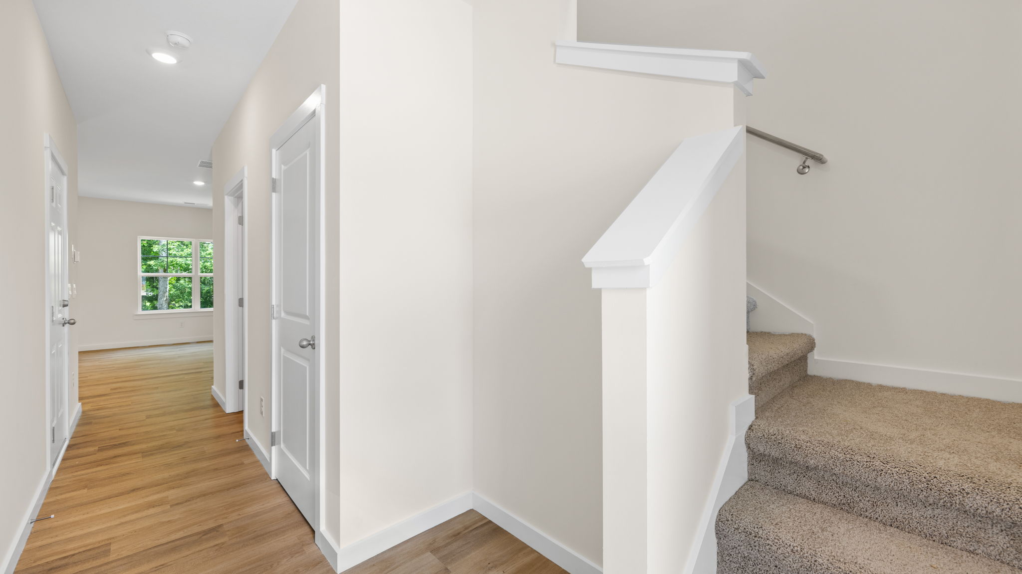 Entryway hallway with carpeted staircase.