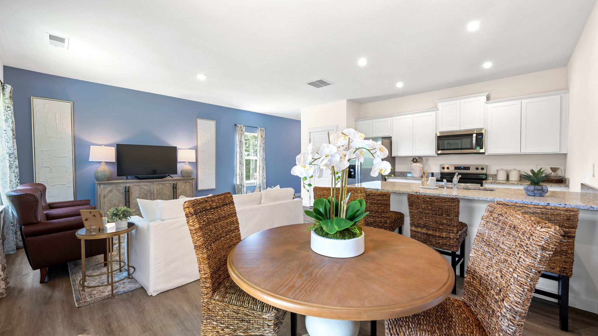 open concept dining and living area with windows and back patio door