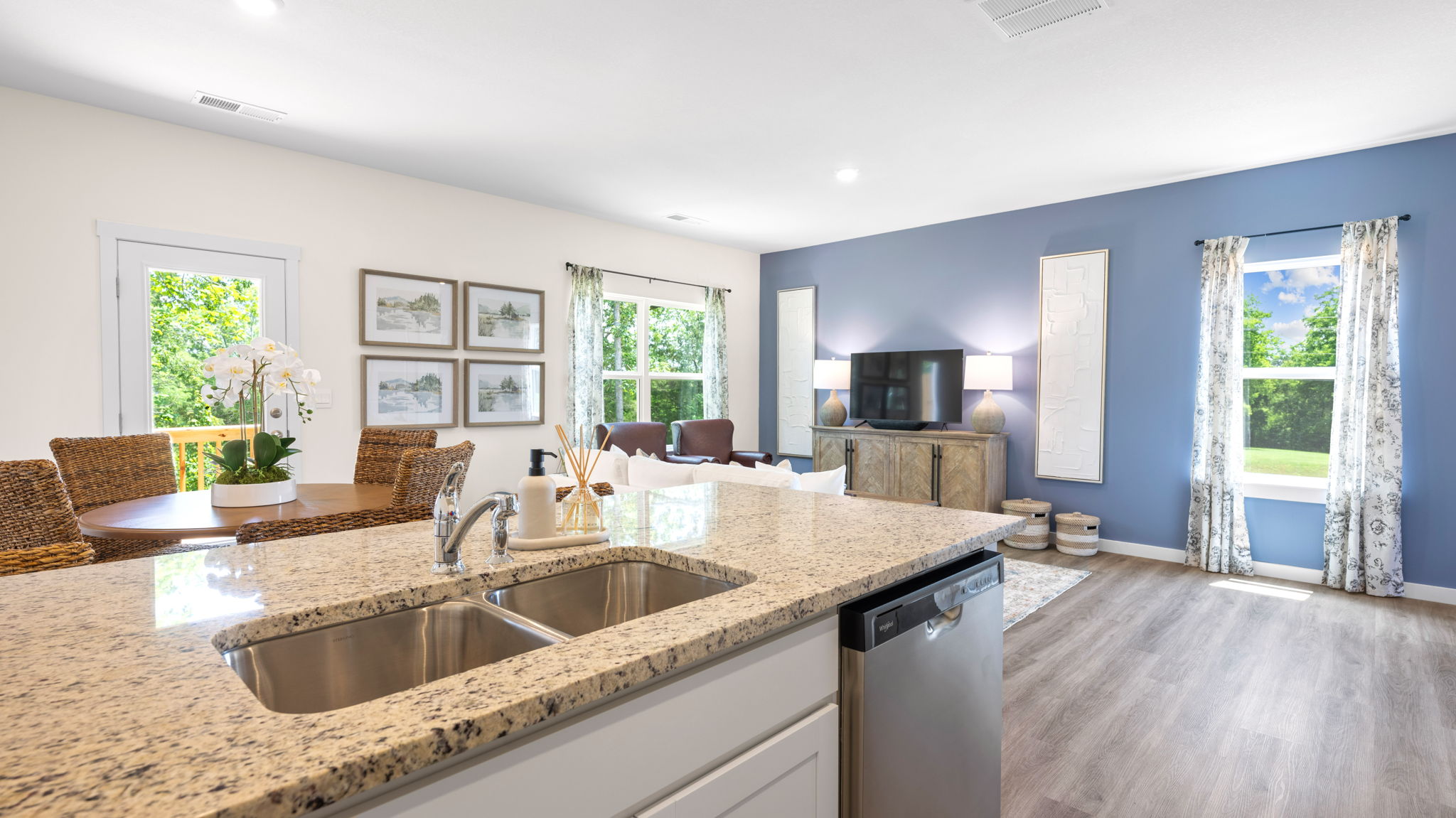 open concept living and dining with windows and back patio door