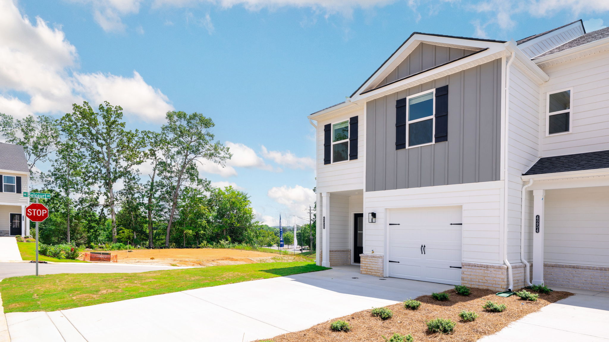 Two story home with neutral exterior and clean landscaping.