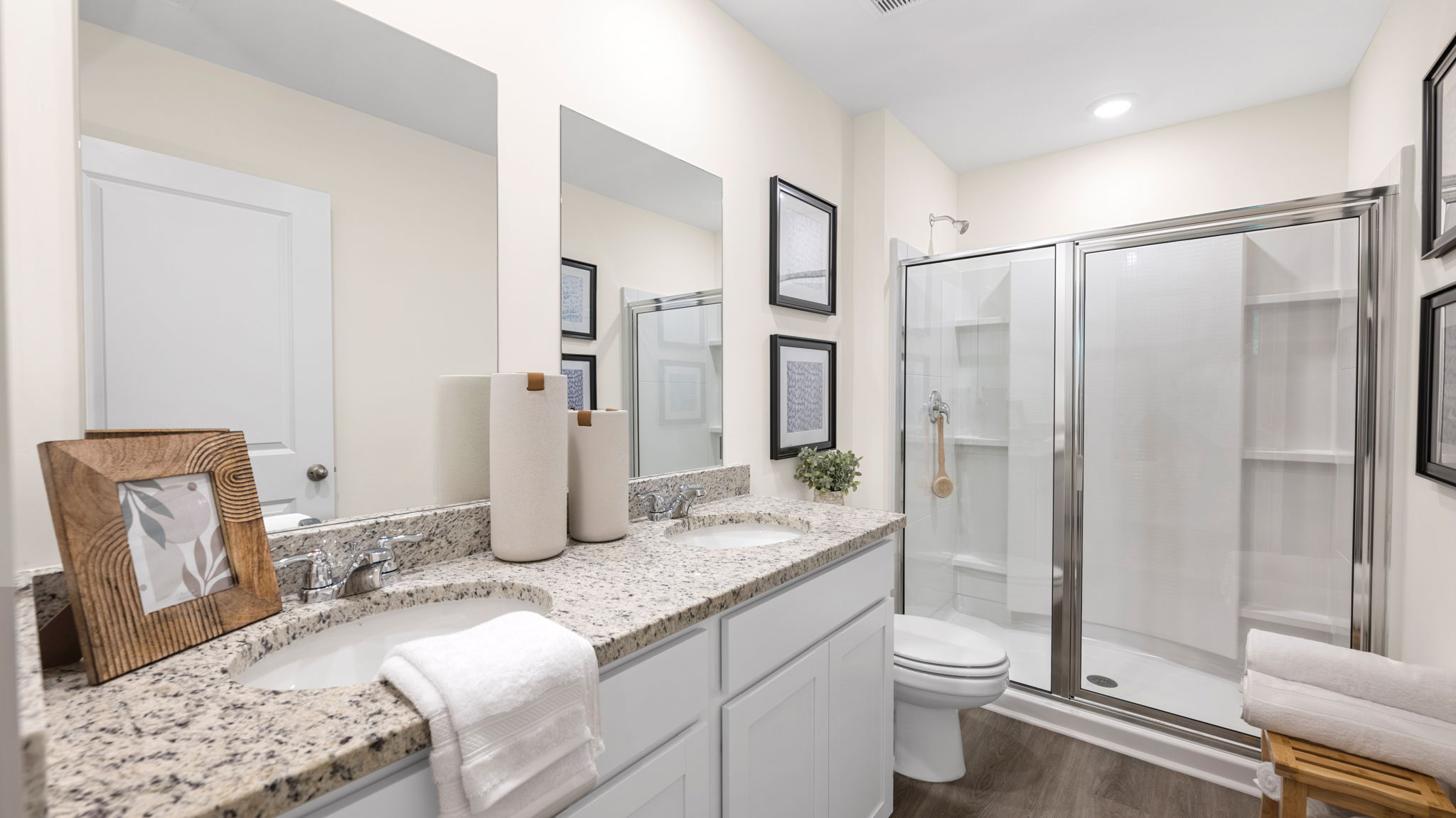 Bathroom with dual sinks and a walk in shower.