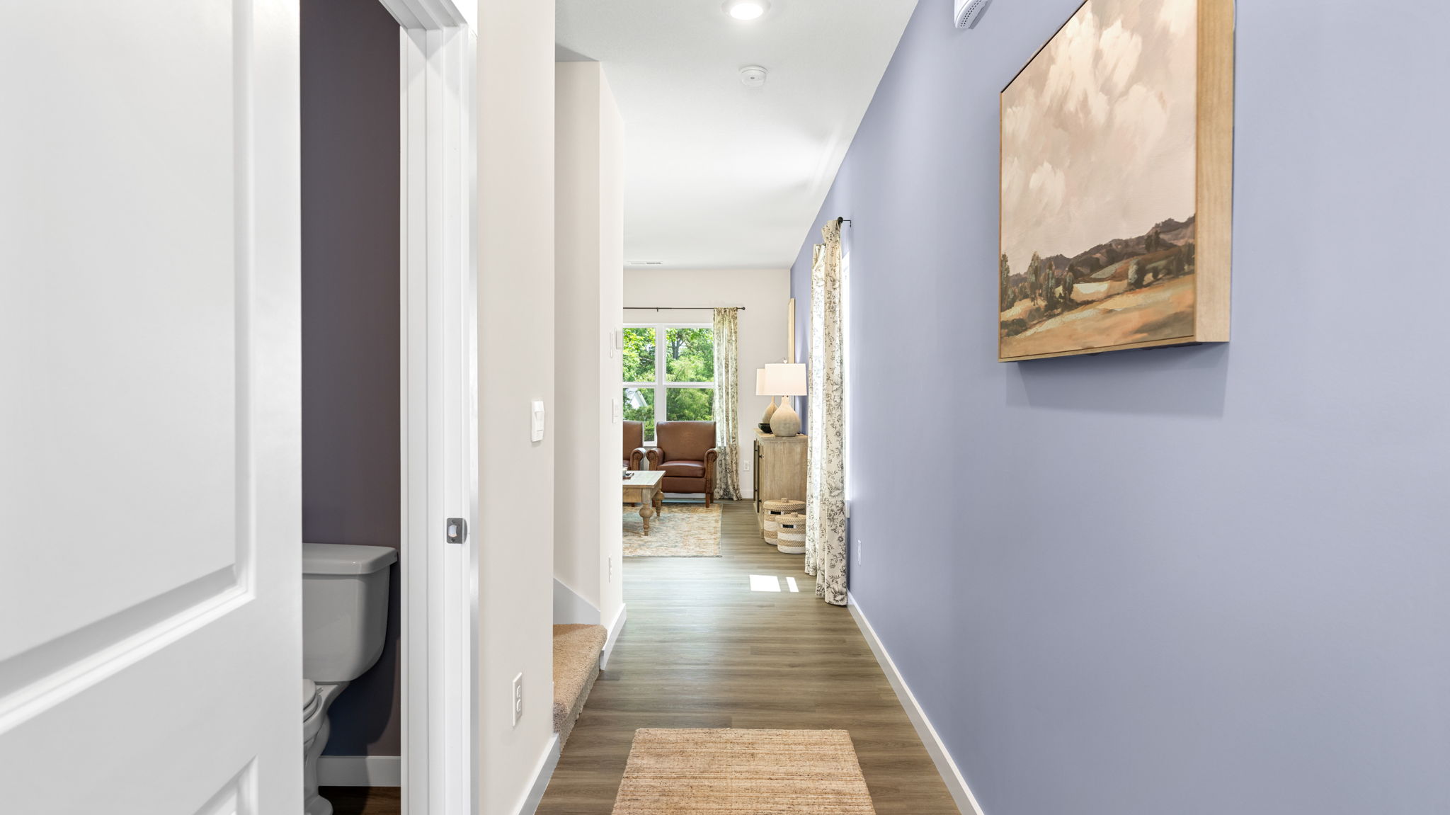 Hallway with access to half bath and living area.