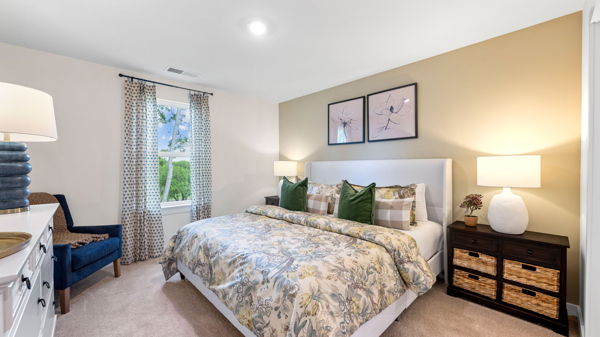 Primary bedroom with carpet, large windows, and simple furnishings.