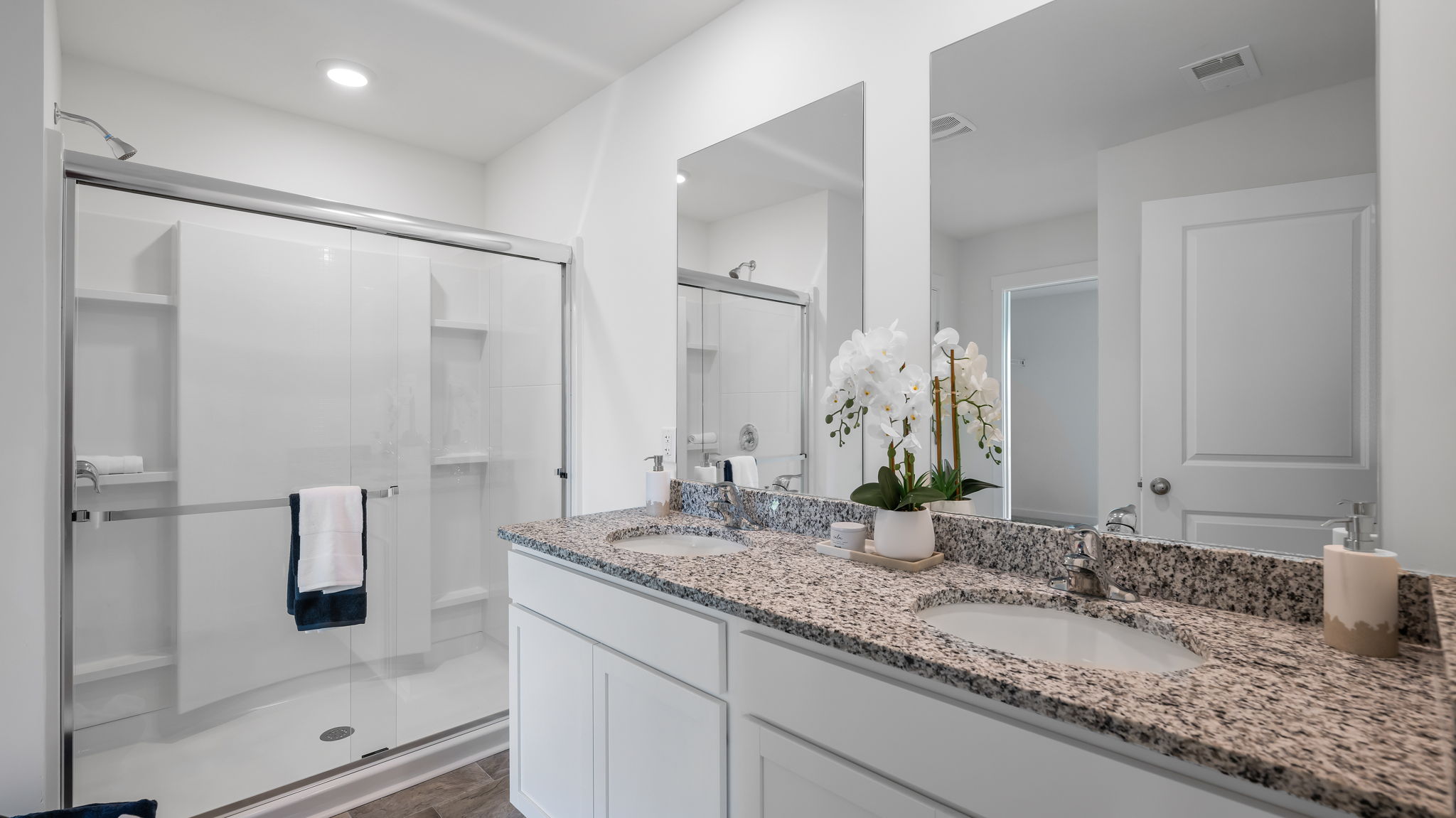 primary bathroom with double vanity and walk-in shower