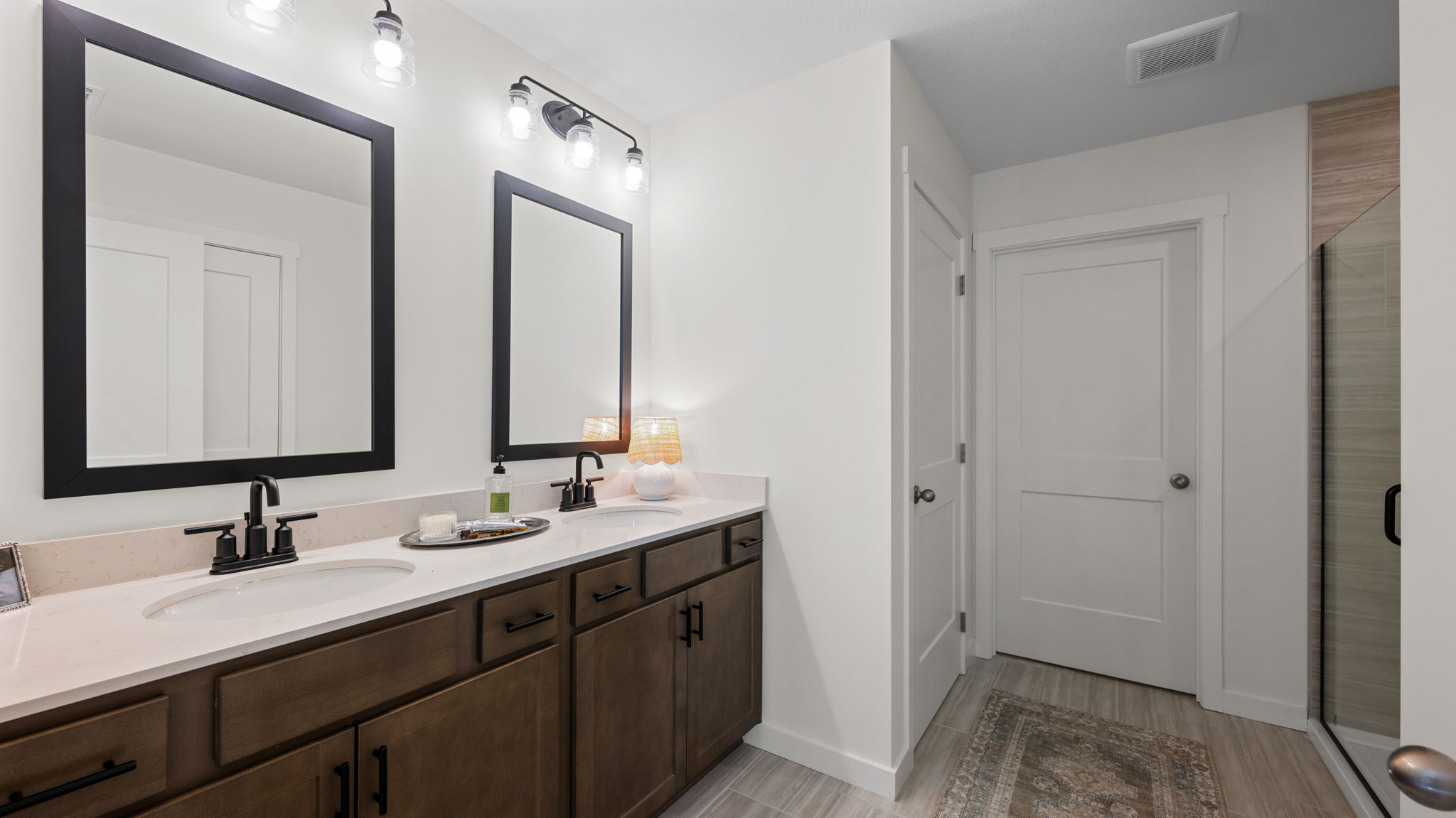primary bathroom with double vanity and walk-in shower