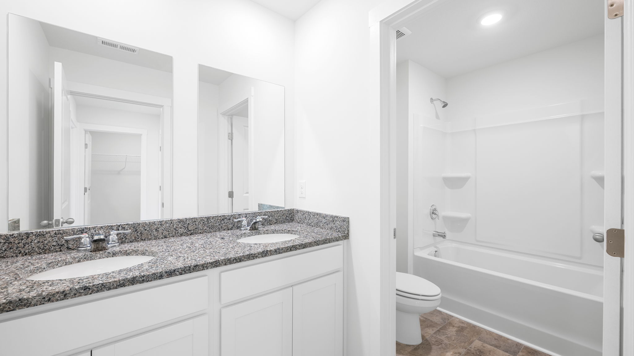 full bathroom with double vanity and shower/ tub duo