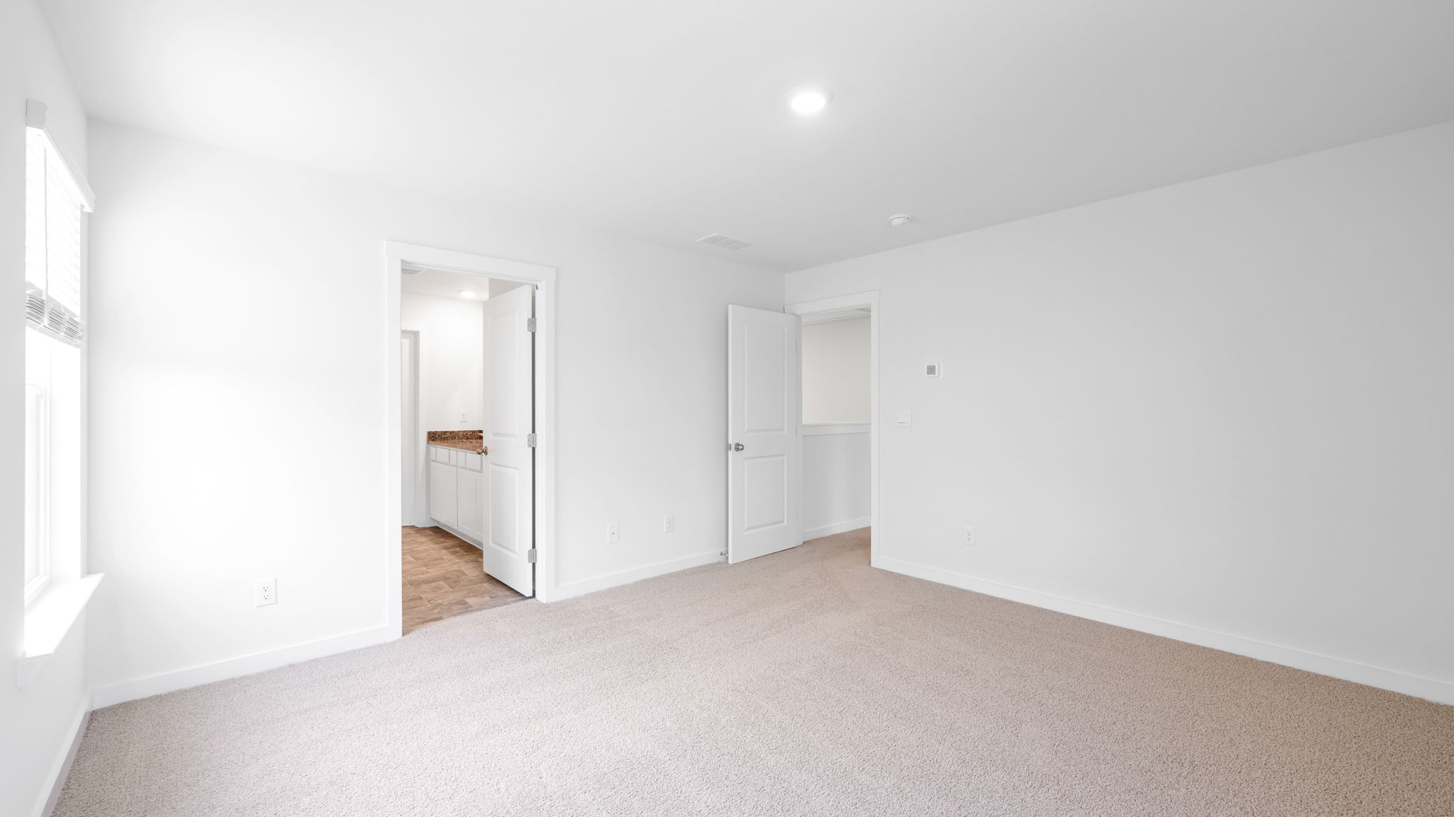 primary bedroom with two single windows and en suite