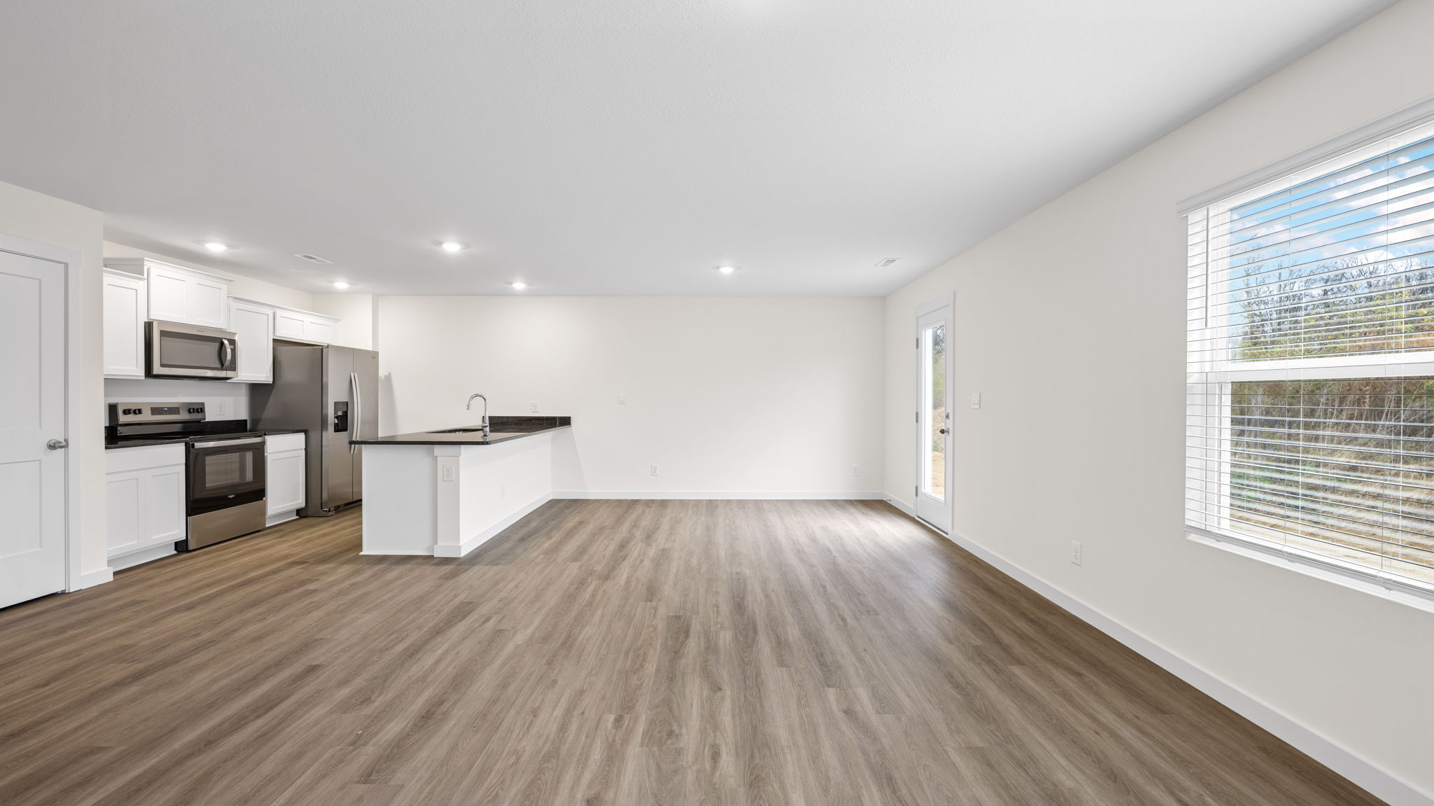 open concept dining and living with double window and back patio door