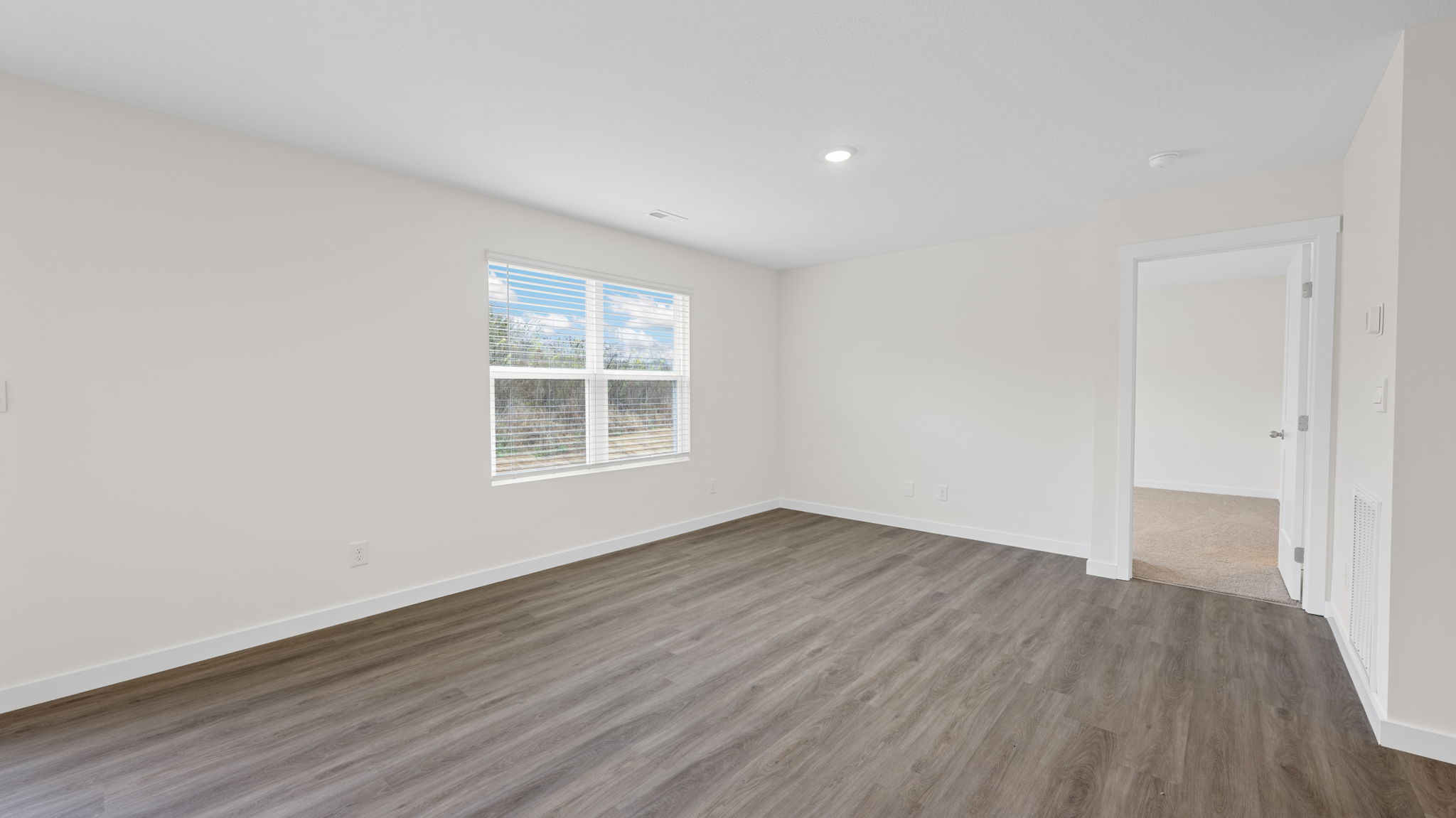 open concept dining and living with double window and back patio door