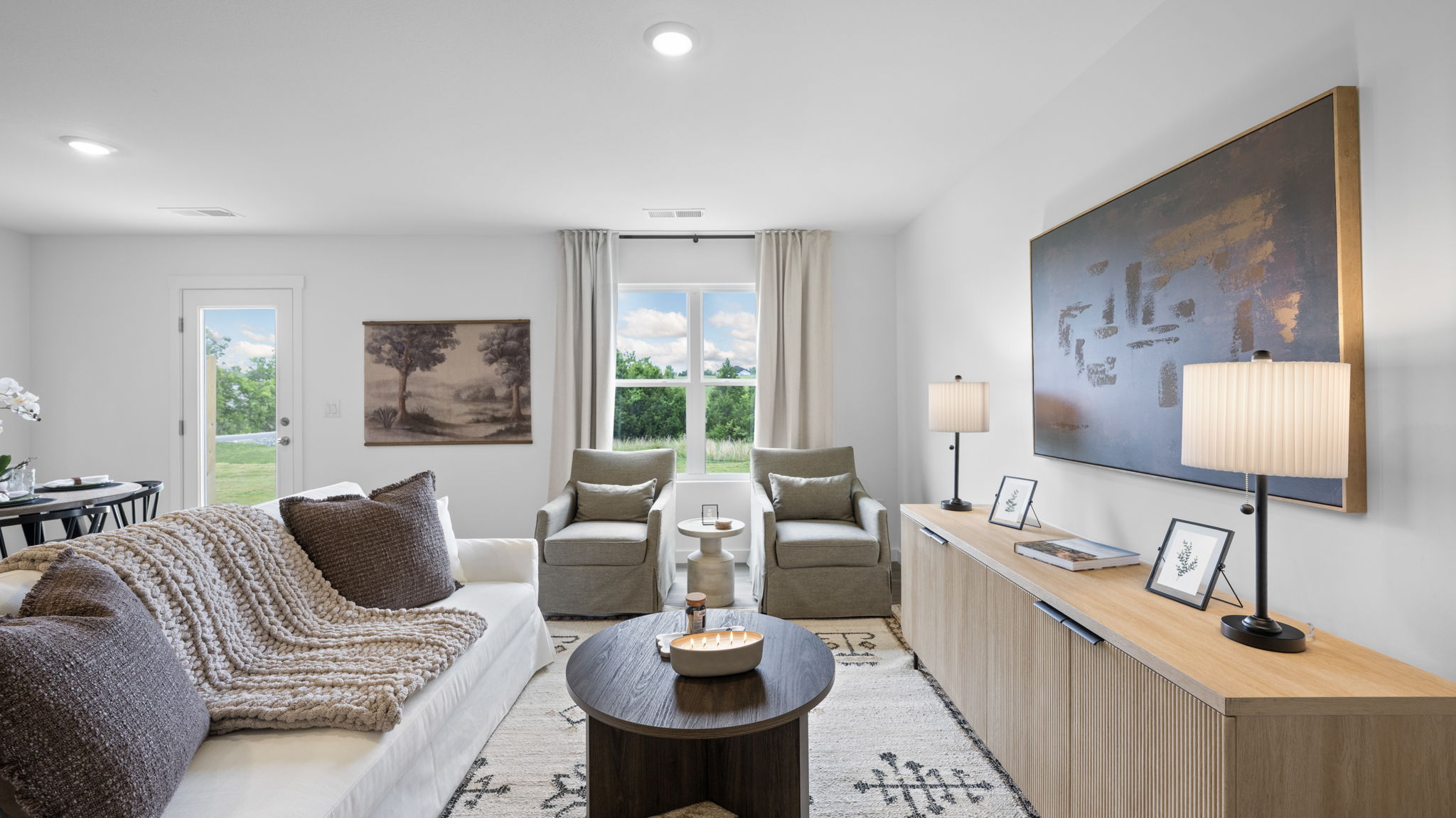 open concept living and dining with windows and back patio door