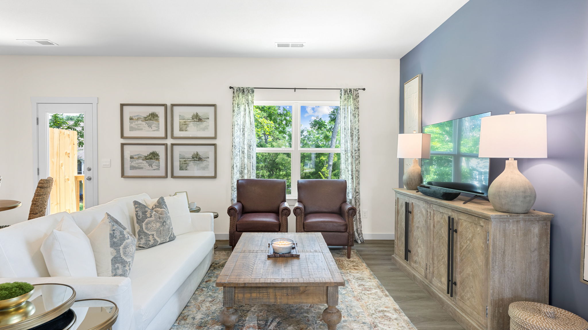 open concept living and dining with windows and back patio door