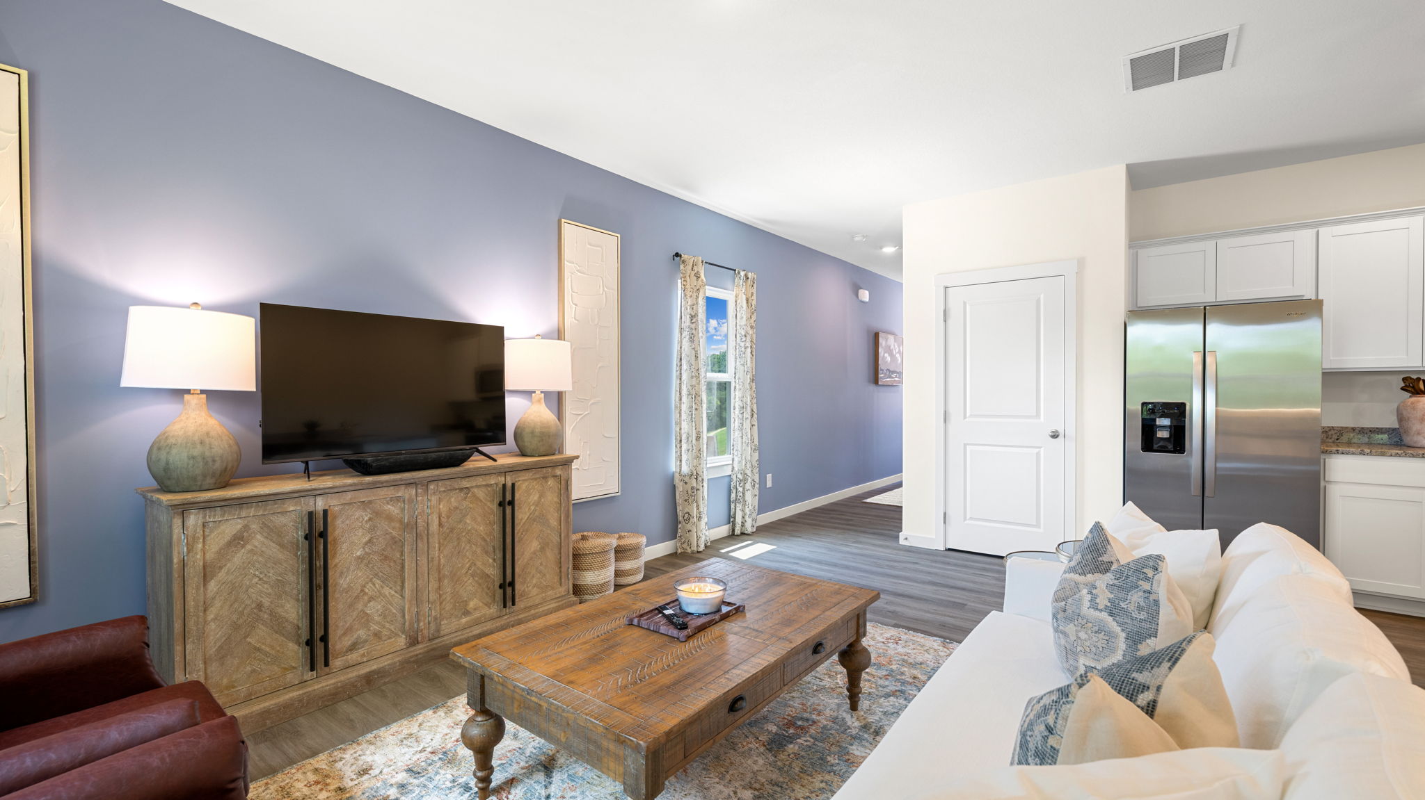 open concept living and dining with windows and back patio door