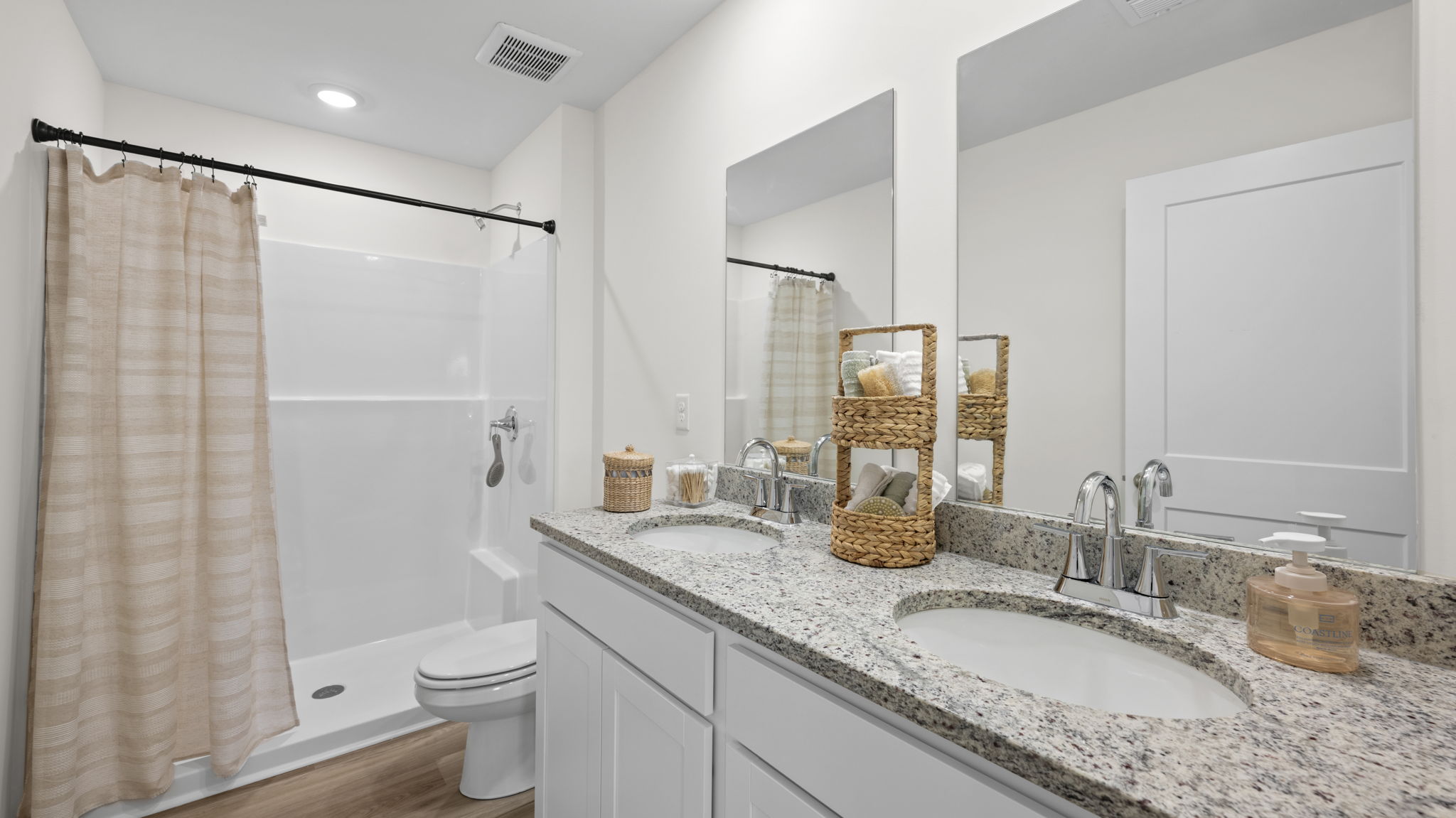 primary bathroom with double vanity and walk-in closet